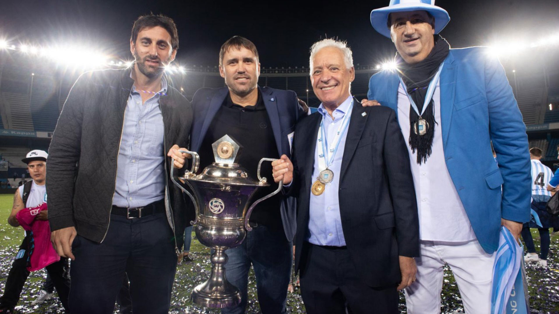 Diego Milito, Eduardo Coudet, Víctor Blanco y Roberto Torres (con la bufanda) junto al trofeo de la Superliga