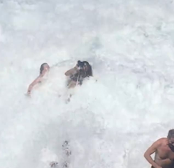 La ola las tomó por sorpresa, mojando la cámara fotográfica Foto: Captura de pantalla