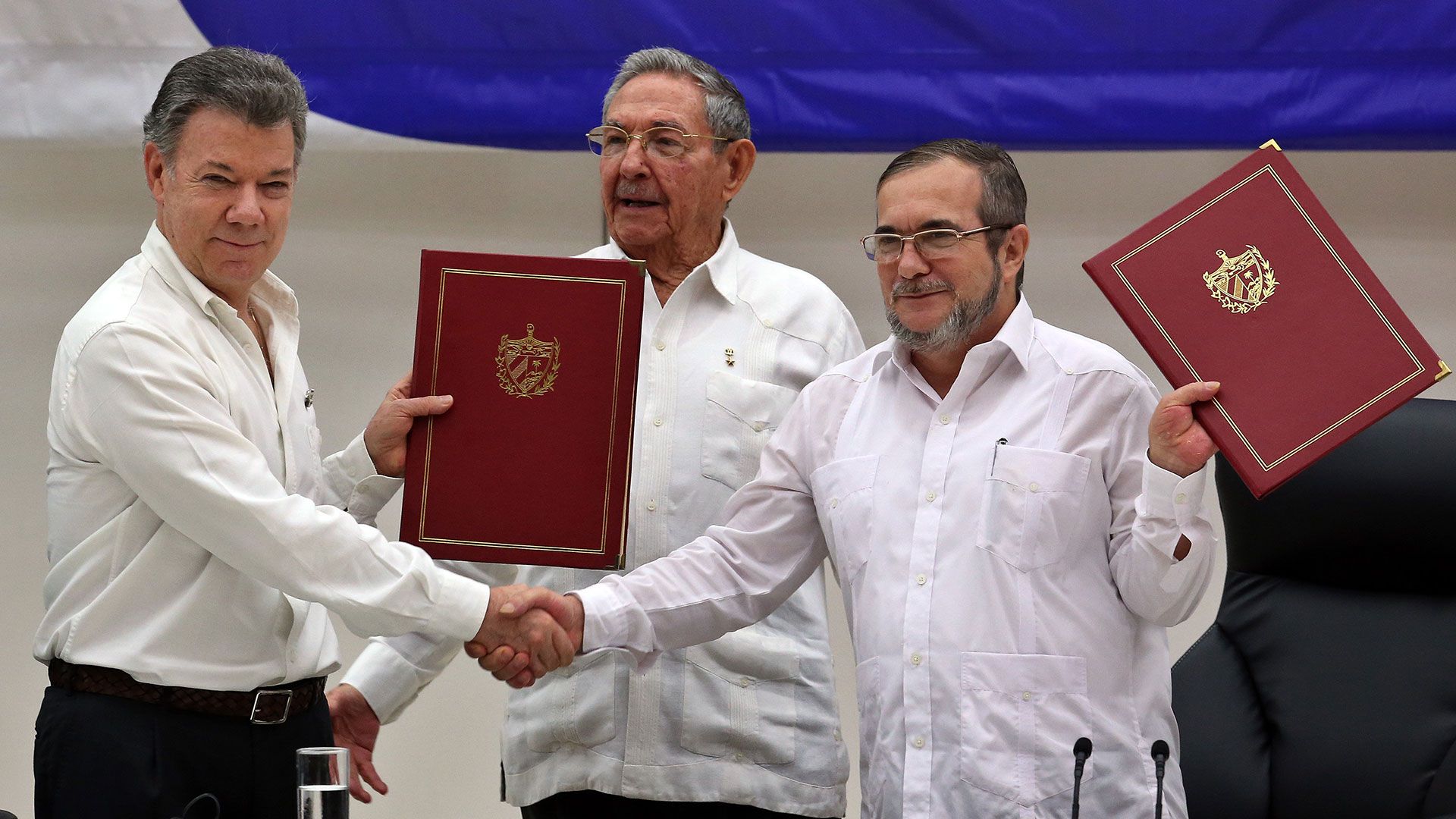 Firma del acuerdo de paz con el presidente Juan Manuel Santos y el exguerrillero de las FARC, alias Timochenko. (EFE)