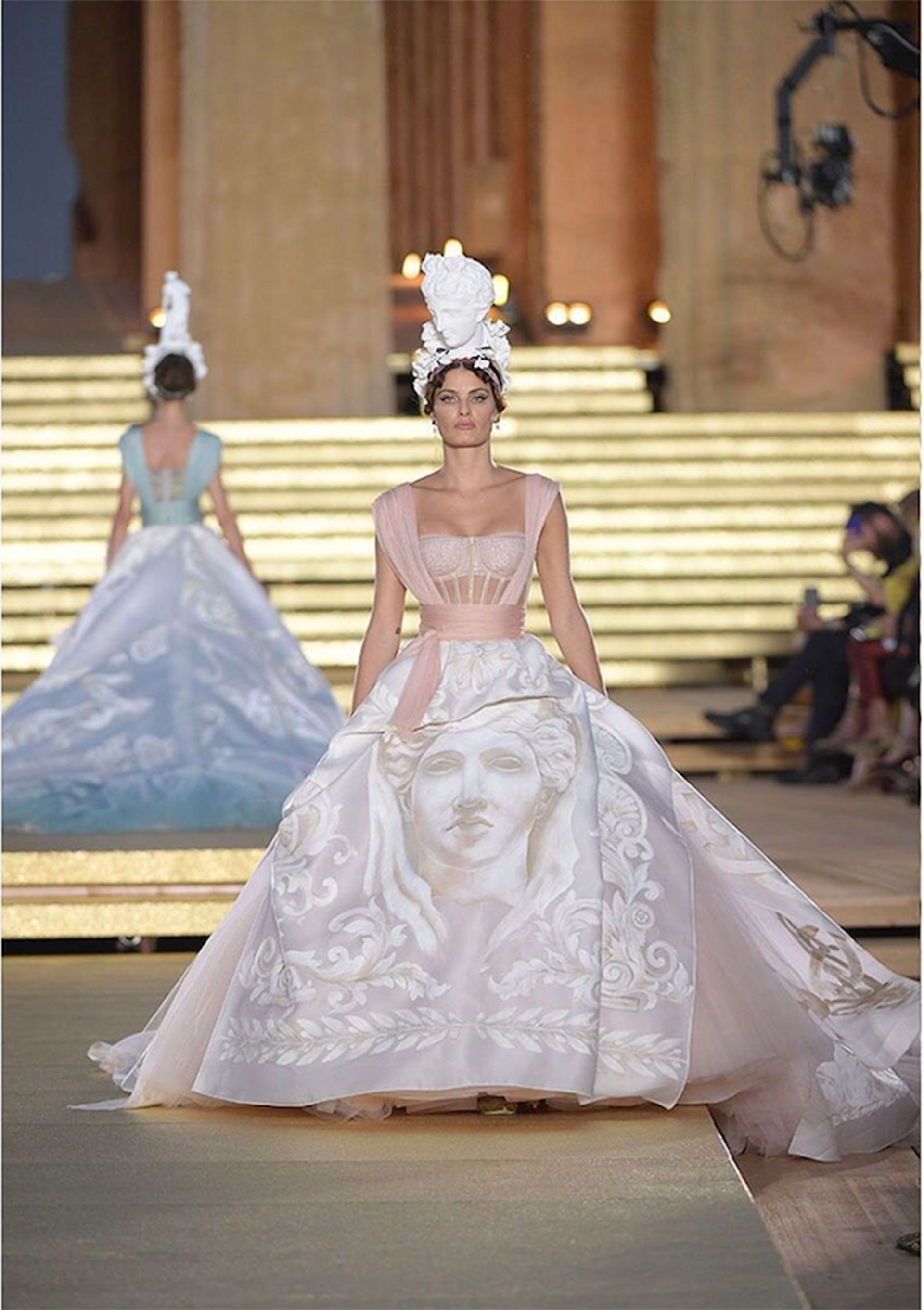 La top model brasilera Isabeli Fontana lleva un vestido con corsé de tul ilusionado. La falda drapeada de organza doble está pintada a mano y cuenta las obras y cualidades de Hera.