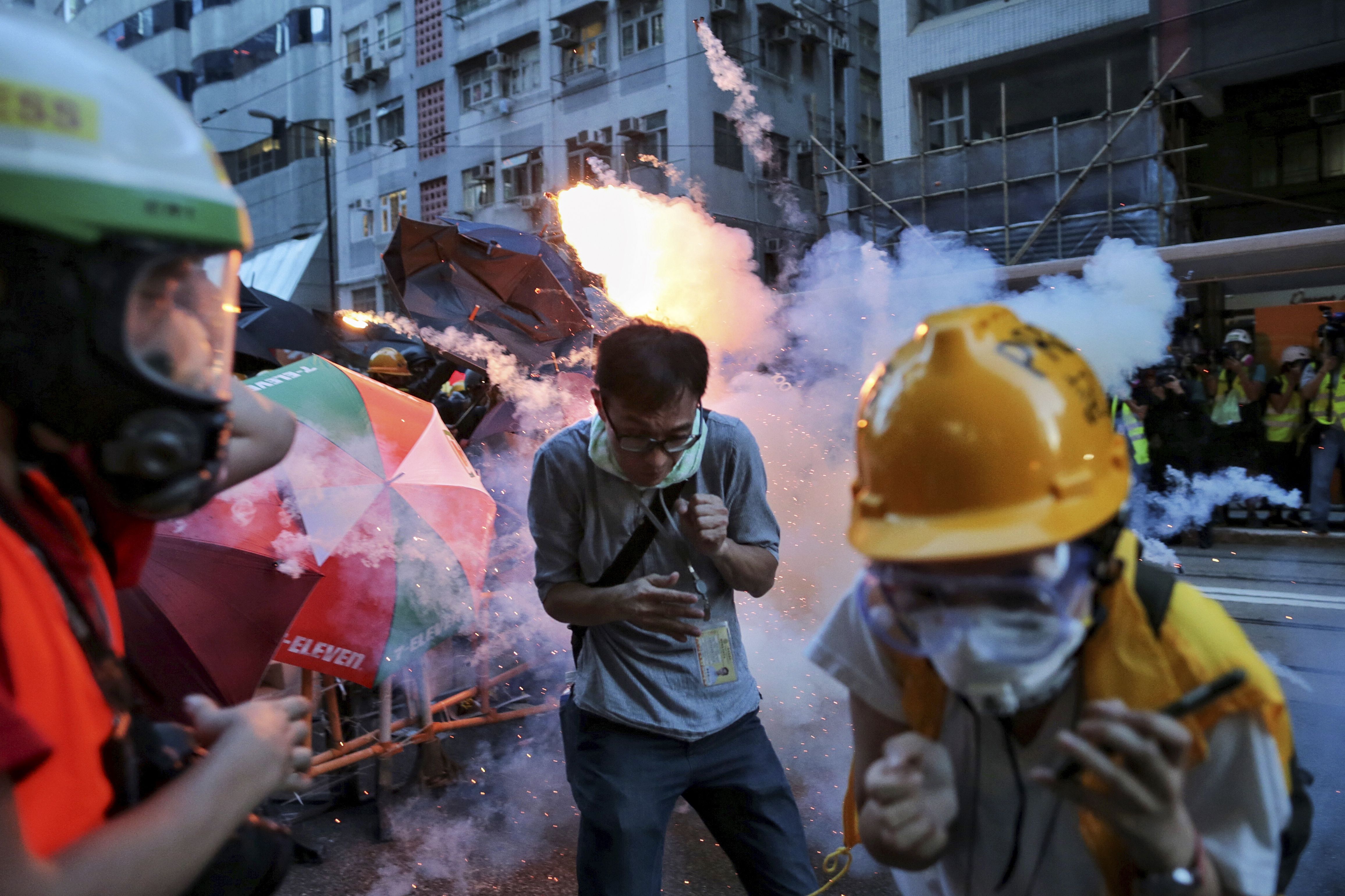 Manifestantes huyen de los gases lacrimógenos que dispara la policía en Hong Kong (Elson Li/HK01 via AP)