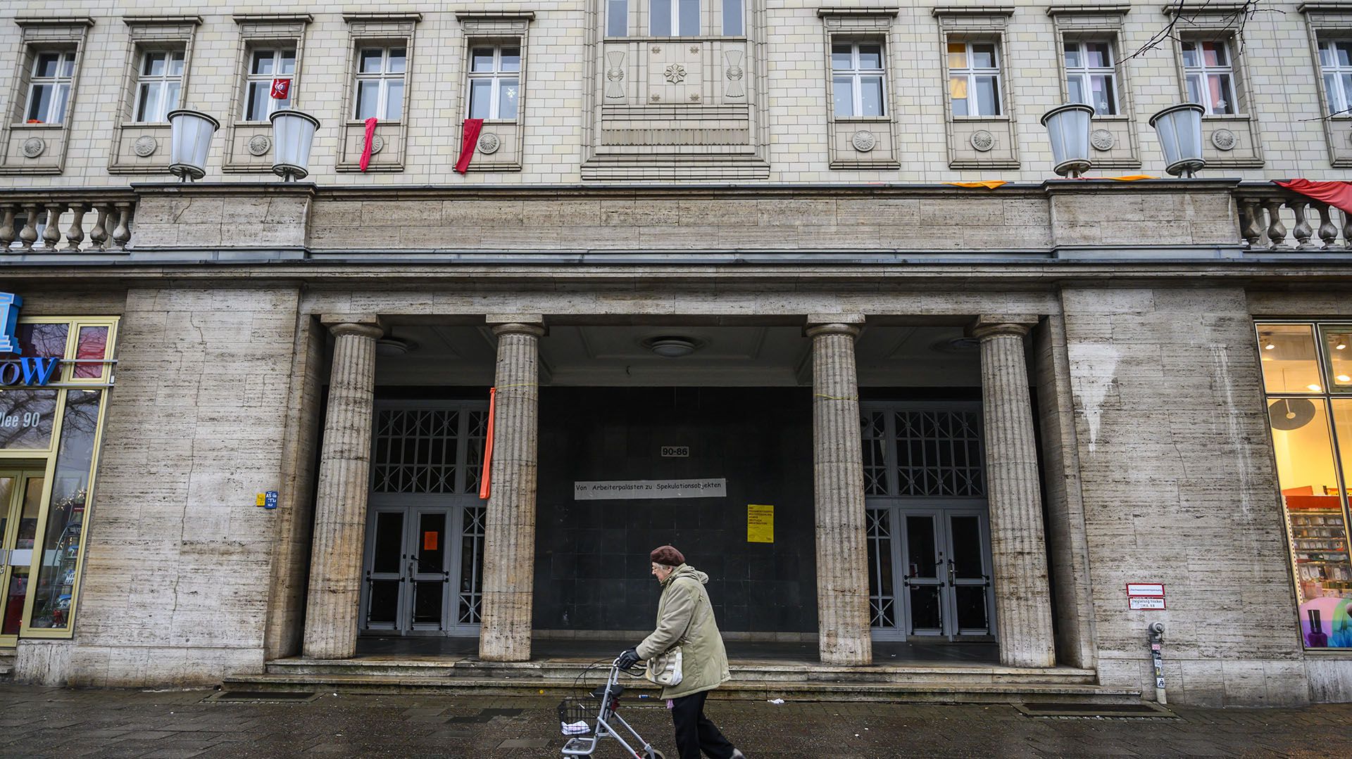 Una mujer pasa por uno de los edificios soviéticos de la avenida Karl Mark en Berlín (Photo by John MACDOUGALL / AFP)