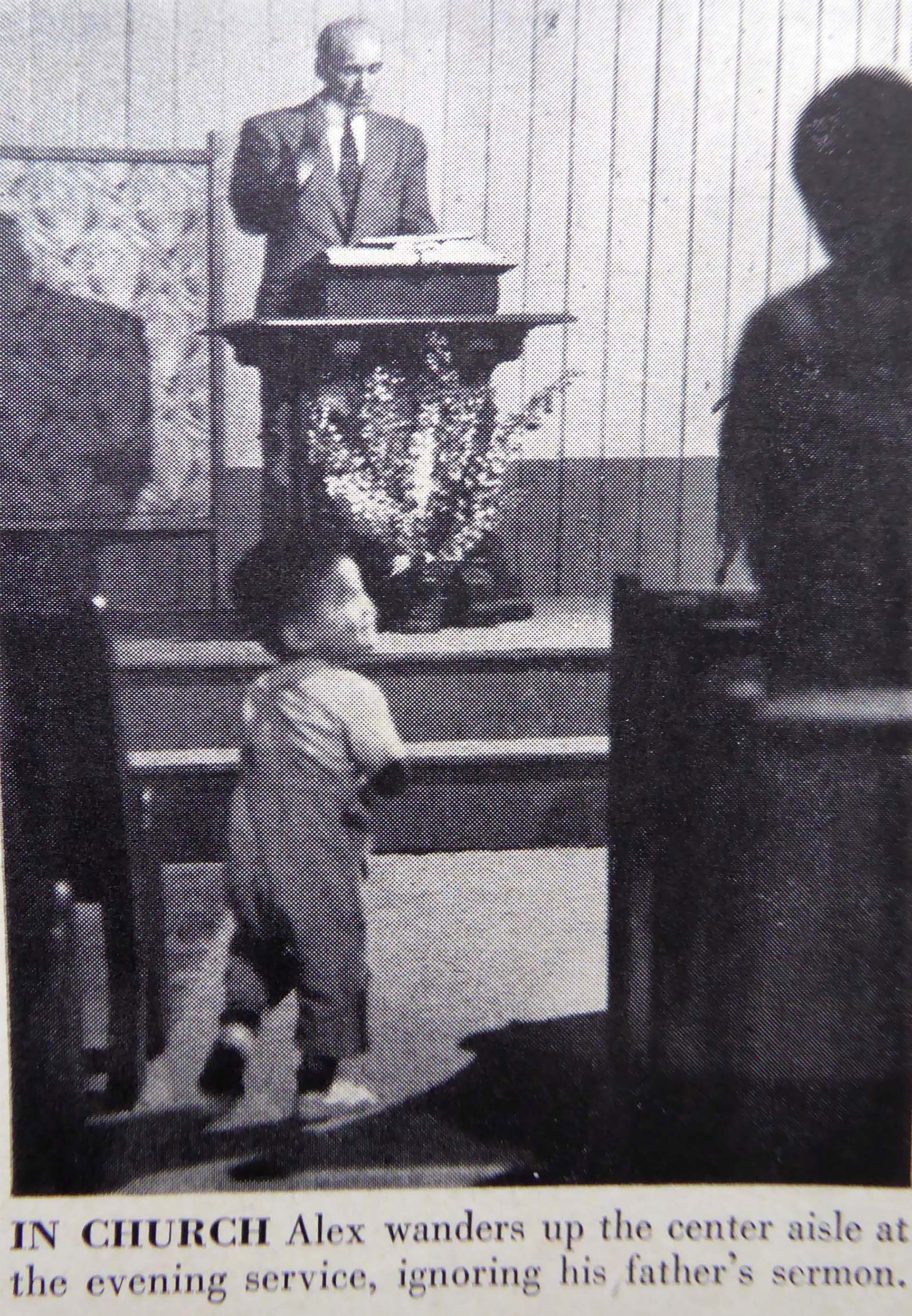 Alexander camina entre los bancos de la Iglesia mientras su padre predica