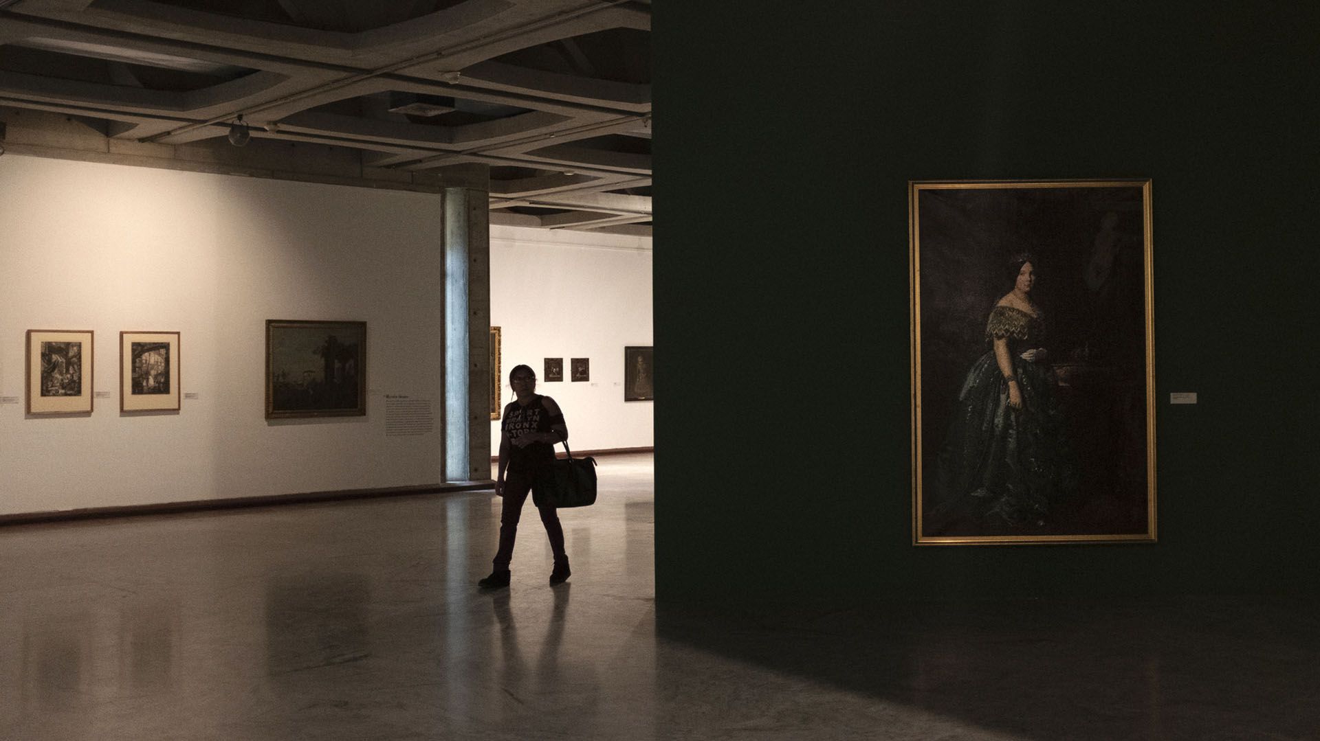 Una mujer pasa entre pinturas europeas en la oscuridad del Museo de Bellas Artes en Caracas (AP Photo/Andrea Hernandez Briceño)
