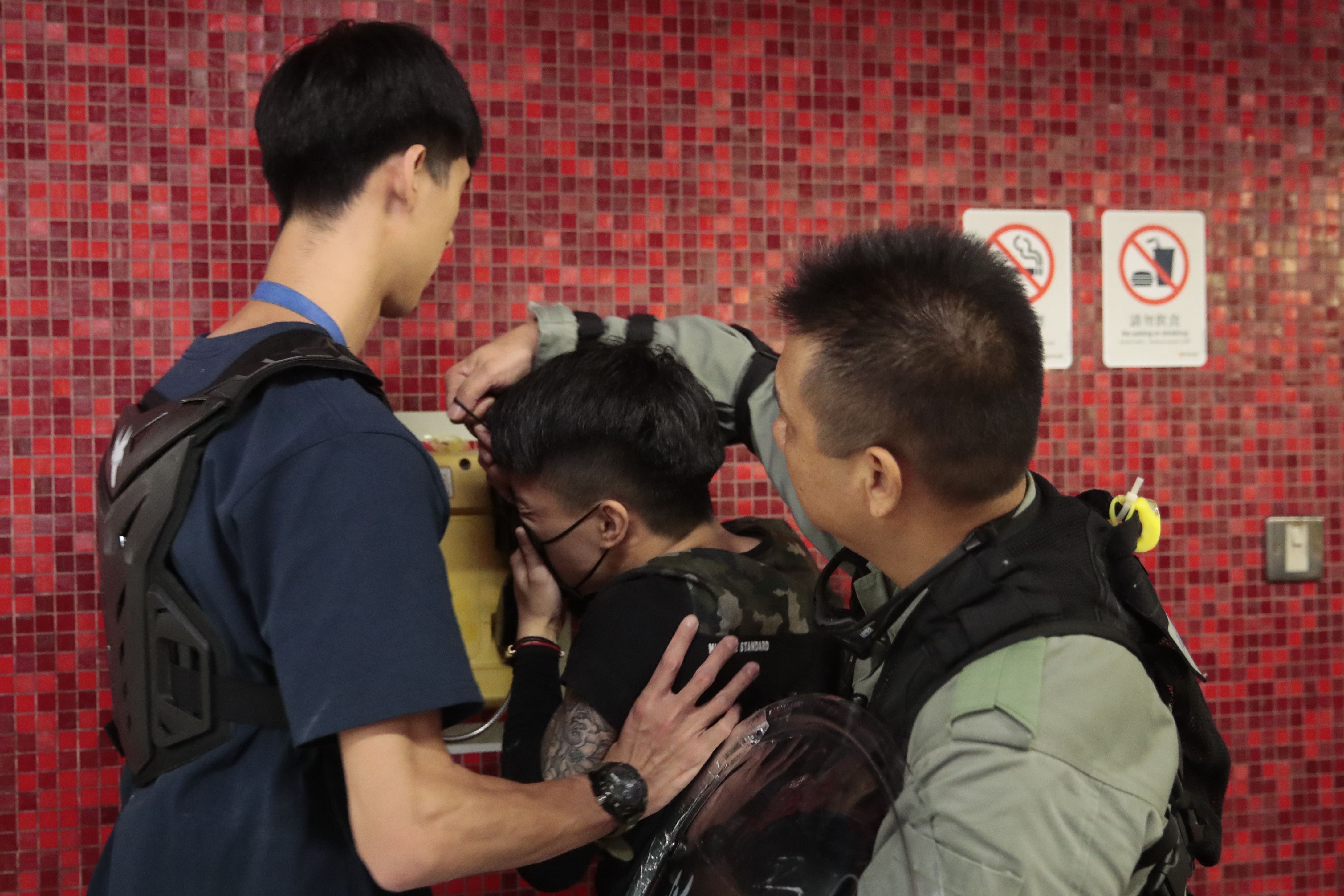 L apolicía retira la máscara de un manifestante después de que bloqueara la puerta de un tren en una estación de metro en Hong Kong, el lunes 2 de septiembre de 2019. (AP Foto/Jae C. Hong)