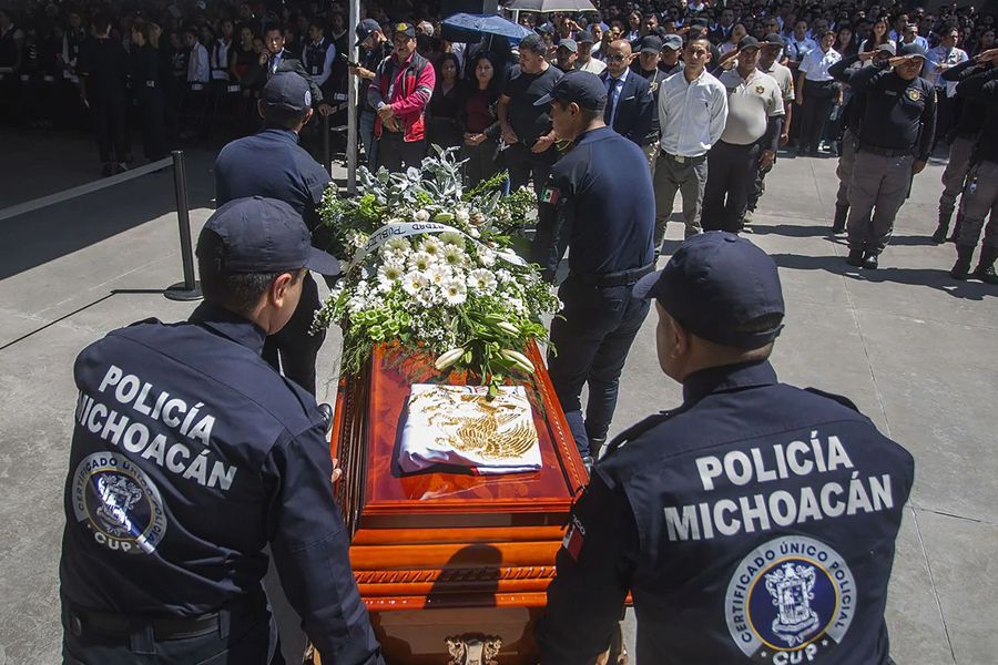 Familiares y miembros de la Policía de Michoacán acuden al funeral de los policías que fueron asesinados en Michoacán el 15 de octubre. (Enrique Castro/ AFP)