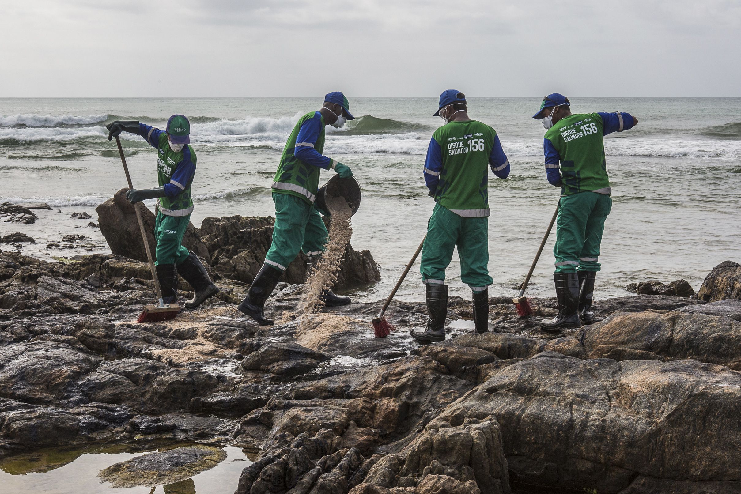 Empleados municipales remueven manchas de crudo en Salvador (ANTONELLO VENERI / AFP)