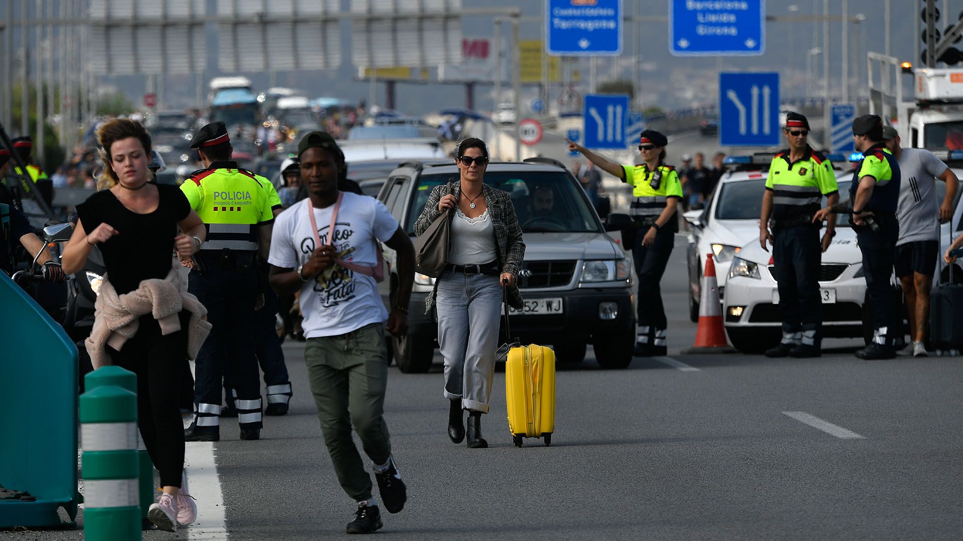 Pasajeros se vieron obligados a bajar de los vehículos e intentar llegar a pie al aeropuerto El Prat (AFP)