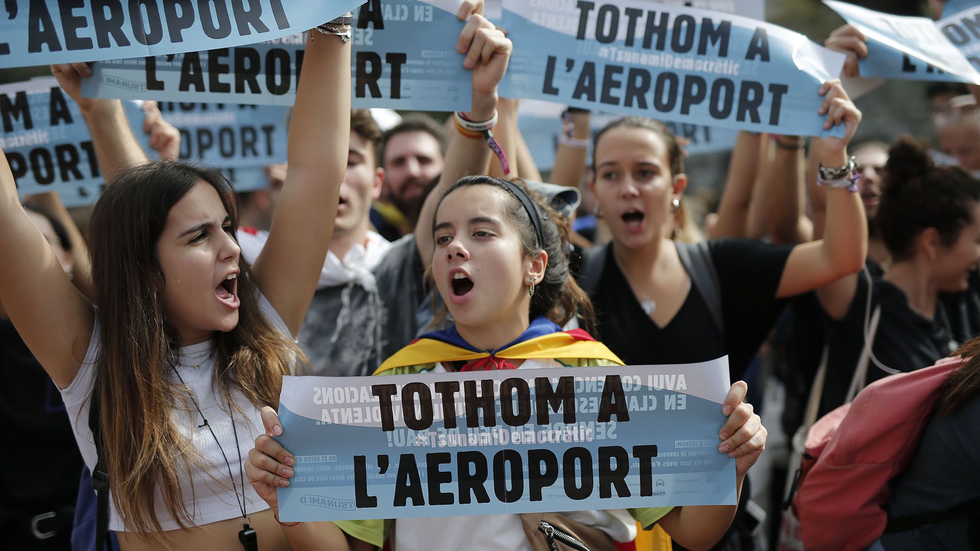 Jóvenes sostienen la consigna "Todos al aeropuerto" (AFP)