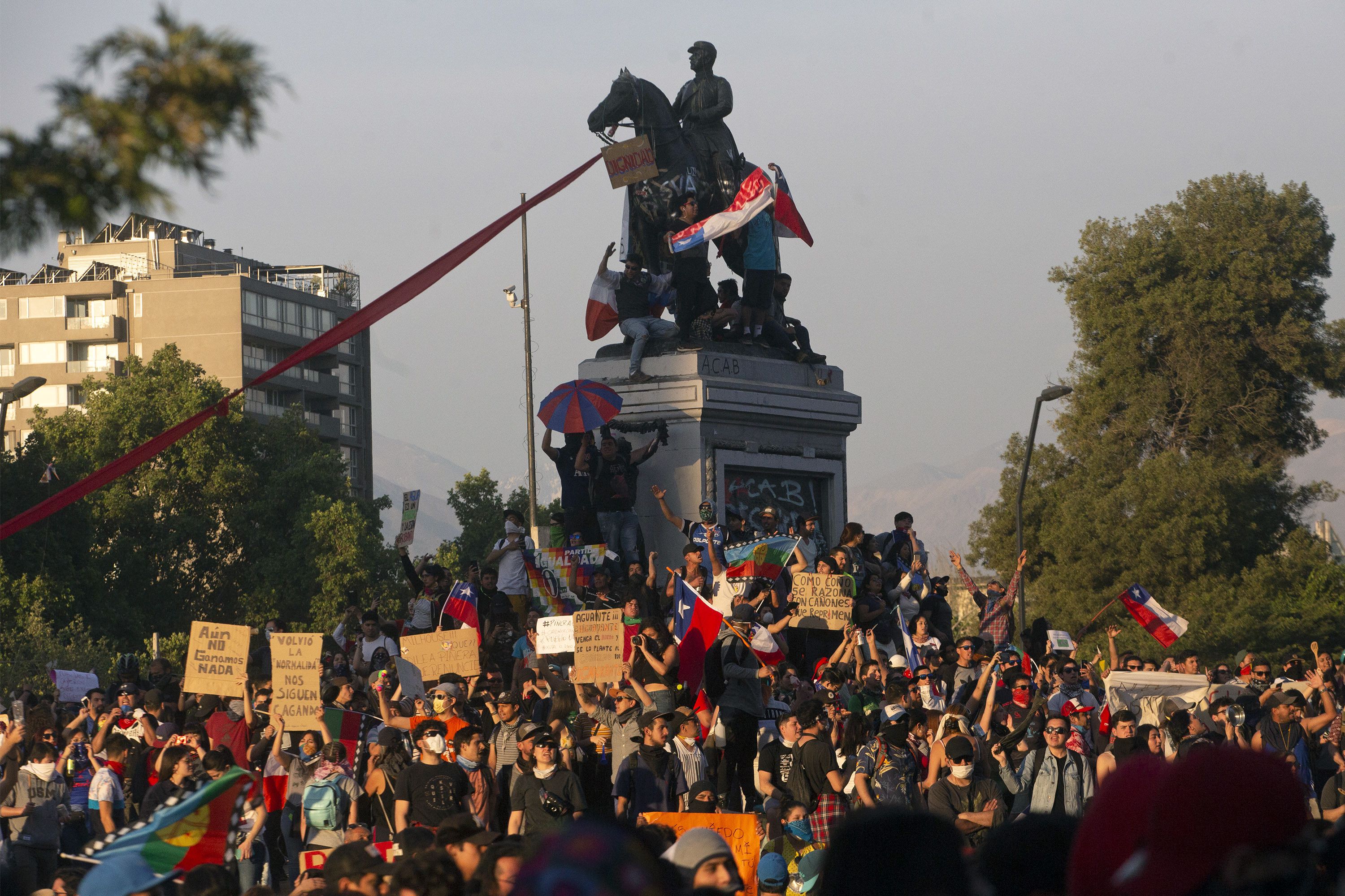 People demonstrate against the government economic policies in Santiago, on October 26, 2019, a day after more than one million people took to the streets for the largest protests in a week of demonstrations. - Chilean President Sebastian Pinera on Saturday announced a major government reshuffle and the military lifted the nighttime curfew in the Chilean capital Santiago, after a week of deadly demonstrations demanding economic reforms and Pinera's resignation. (Photo by CLAUDIO REYES / AFP)