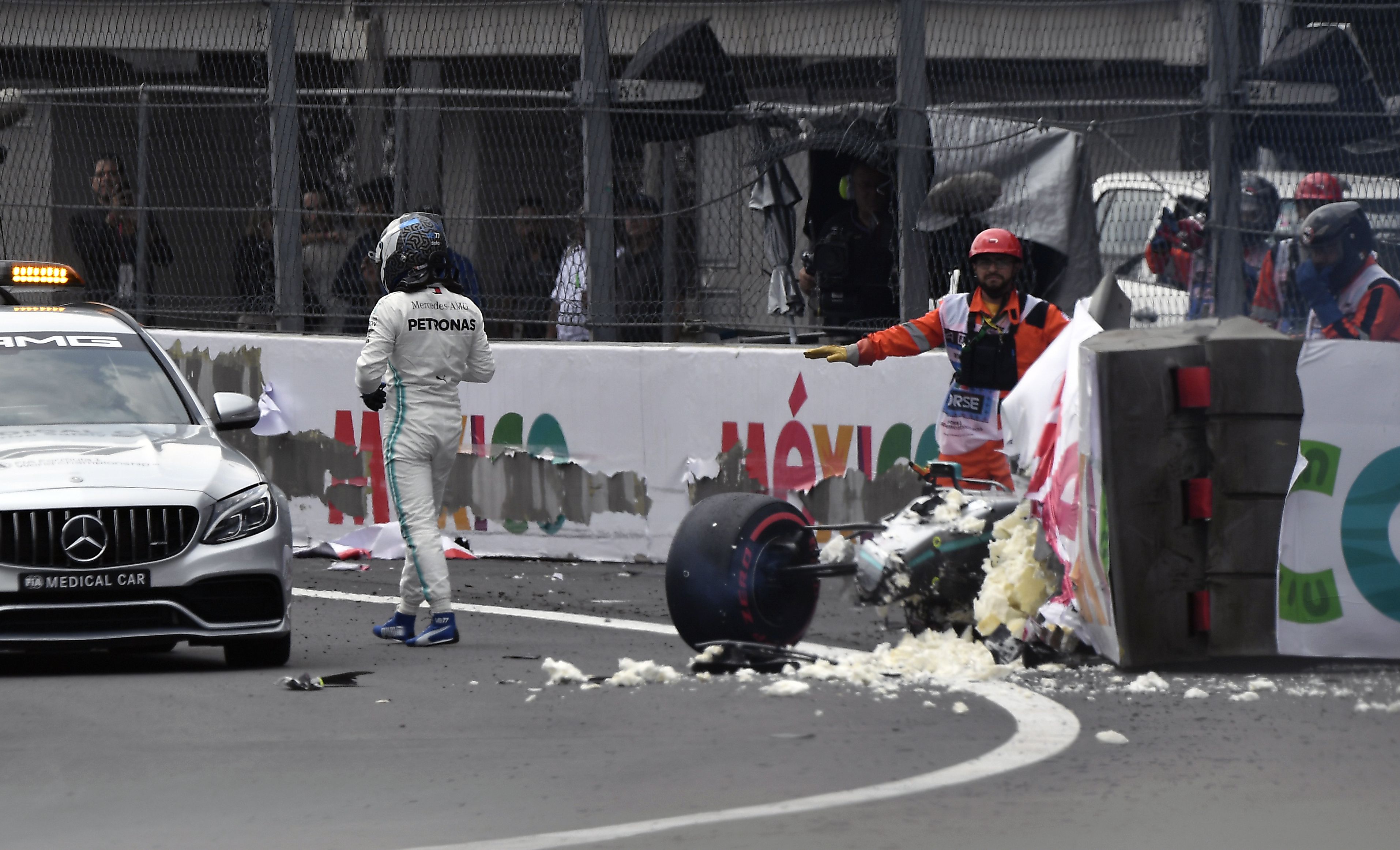 Mercedes Benz's Finnish driver Valtteri Bottas (L) walks after crashing his car during the qualifying session of the F1 Mexico Grand Prix at the Hermanos Rodriguez circuit in Mexico City on October 26, 2019. (Photo by ALFREDO ESTRELLA / AFP)