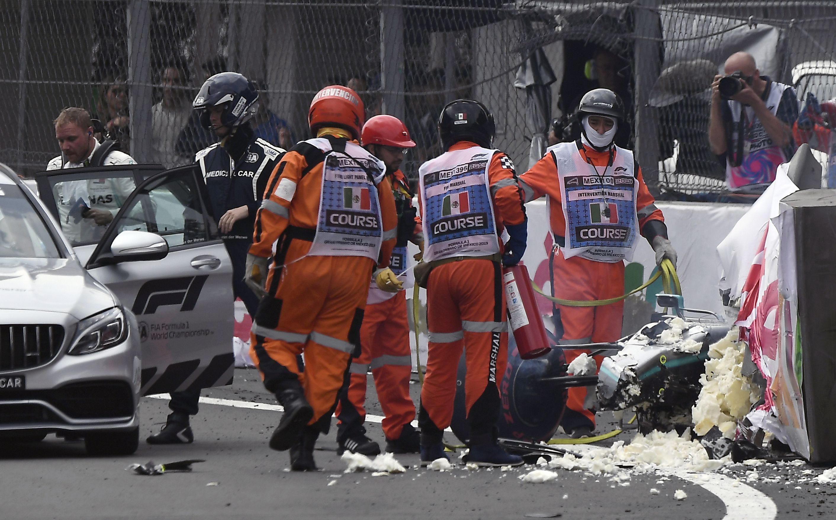 Mercedes Benz's Finnish driver Valtteri Bottas (L) leaves the racing track after crashing his car during the qualifying session of the F1 Mexico Grand Prix at the Hermanos Rodriguez circuit in Mexico City on October 26, 2019. (Photo by ALFREDO ESTRELLA / AFP)