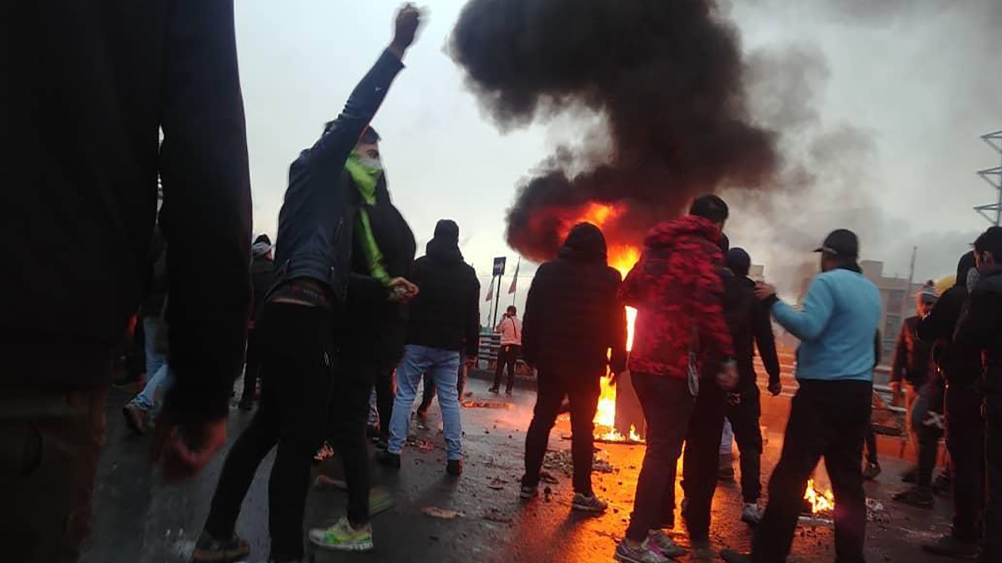 Iranian protesters gather around a fire during a demonstration against an increase in gasoline prices in the capital Tehran, on November 16, 2019. - One person was killed and others injured in protests across Iran, hours after a surprise decision to increase petrol prices by 50 percent for the first 60 litres and 300 percent for anything above that each month, and impose rationing. Authorities said the move was aimed at helping needy citizens, and expected to generate 300 trillion rials ($2.55 billion) per annum. (Photo by - / AFP)