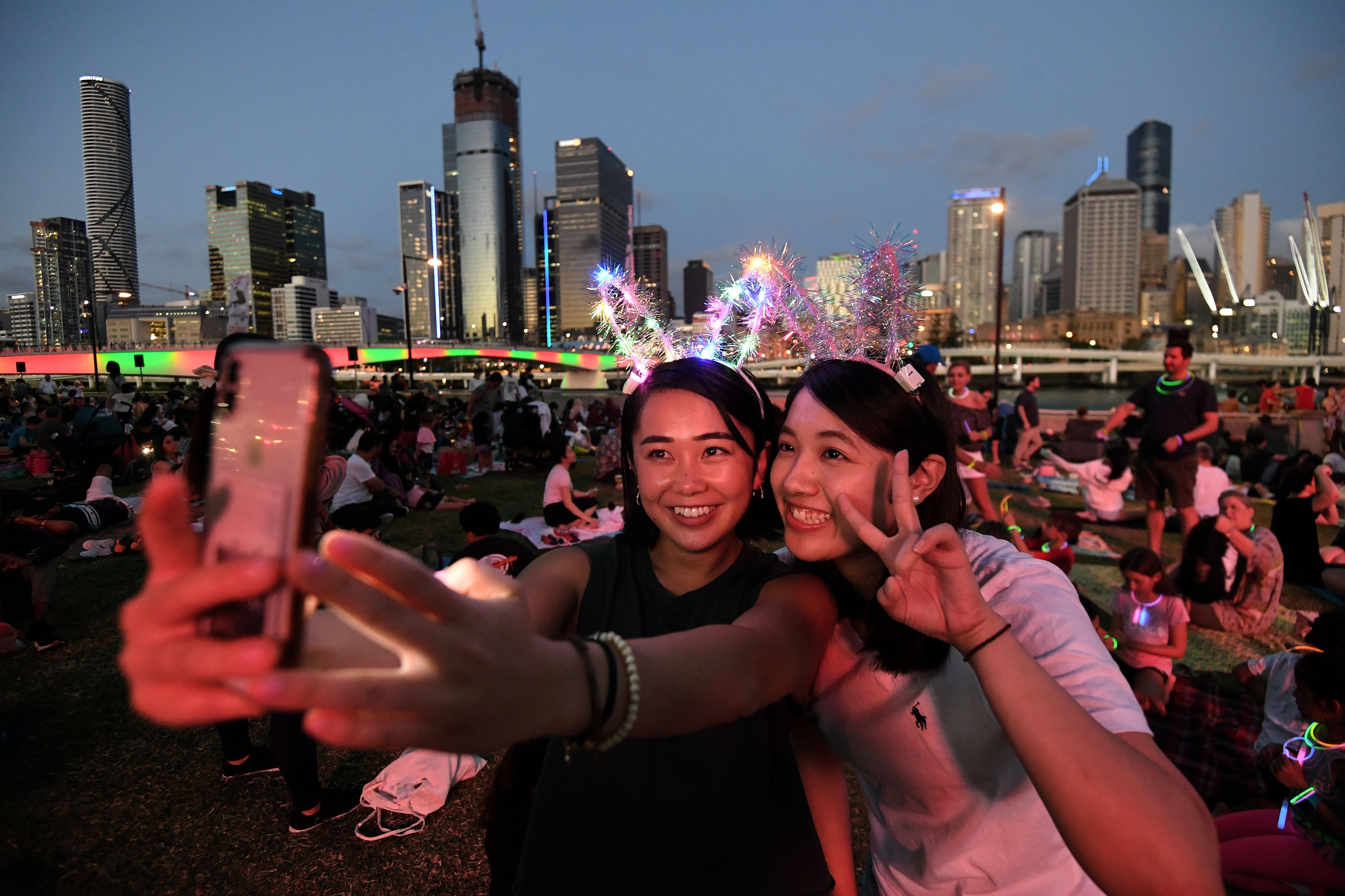 Dos mujeres esperan el show de fuegos artificiales frente a la bahía de Brisbane en Australia