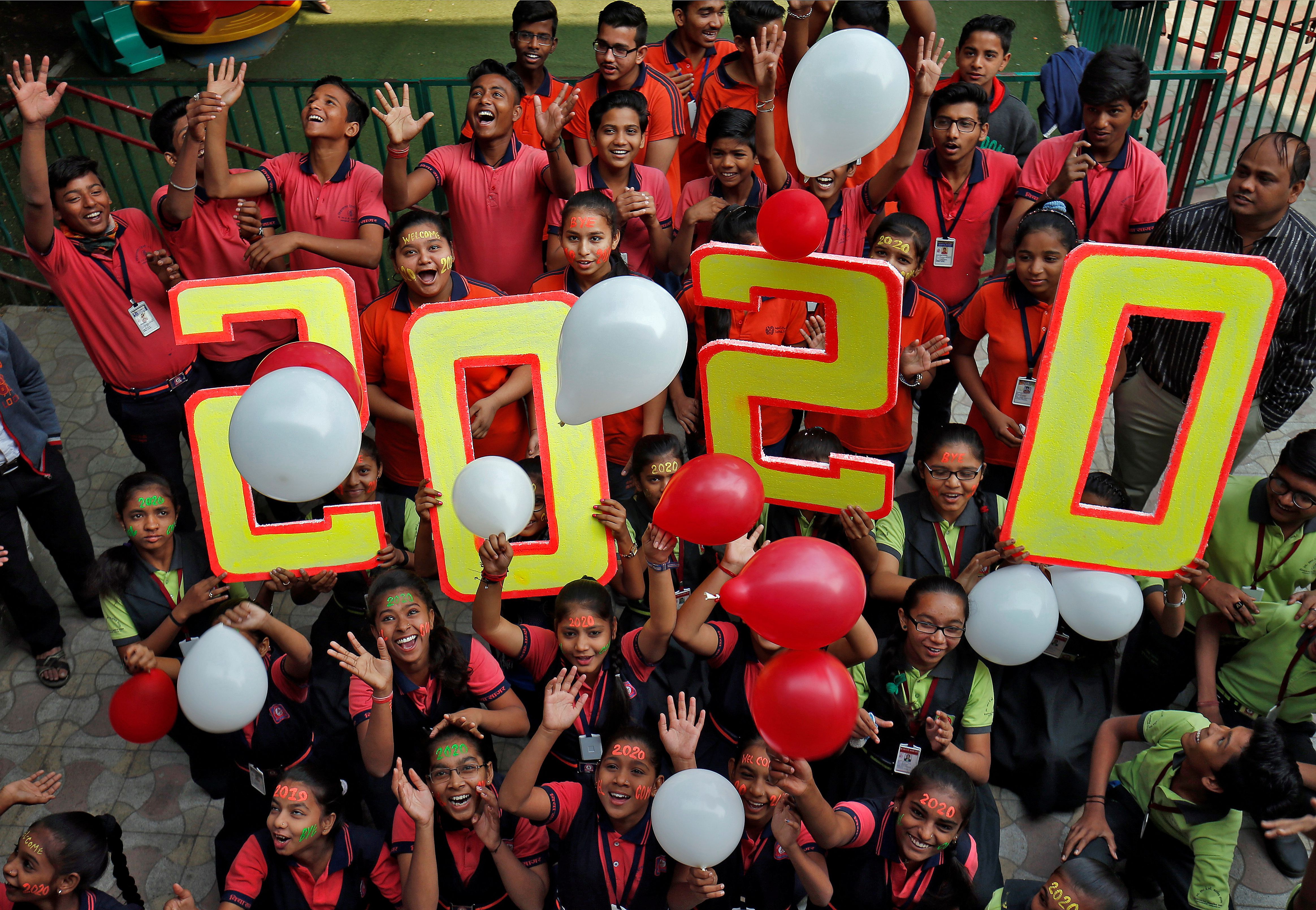 Alumnos de una escuela de Ahmedabad, India, celebran la llegad adel 2020.