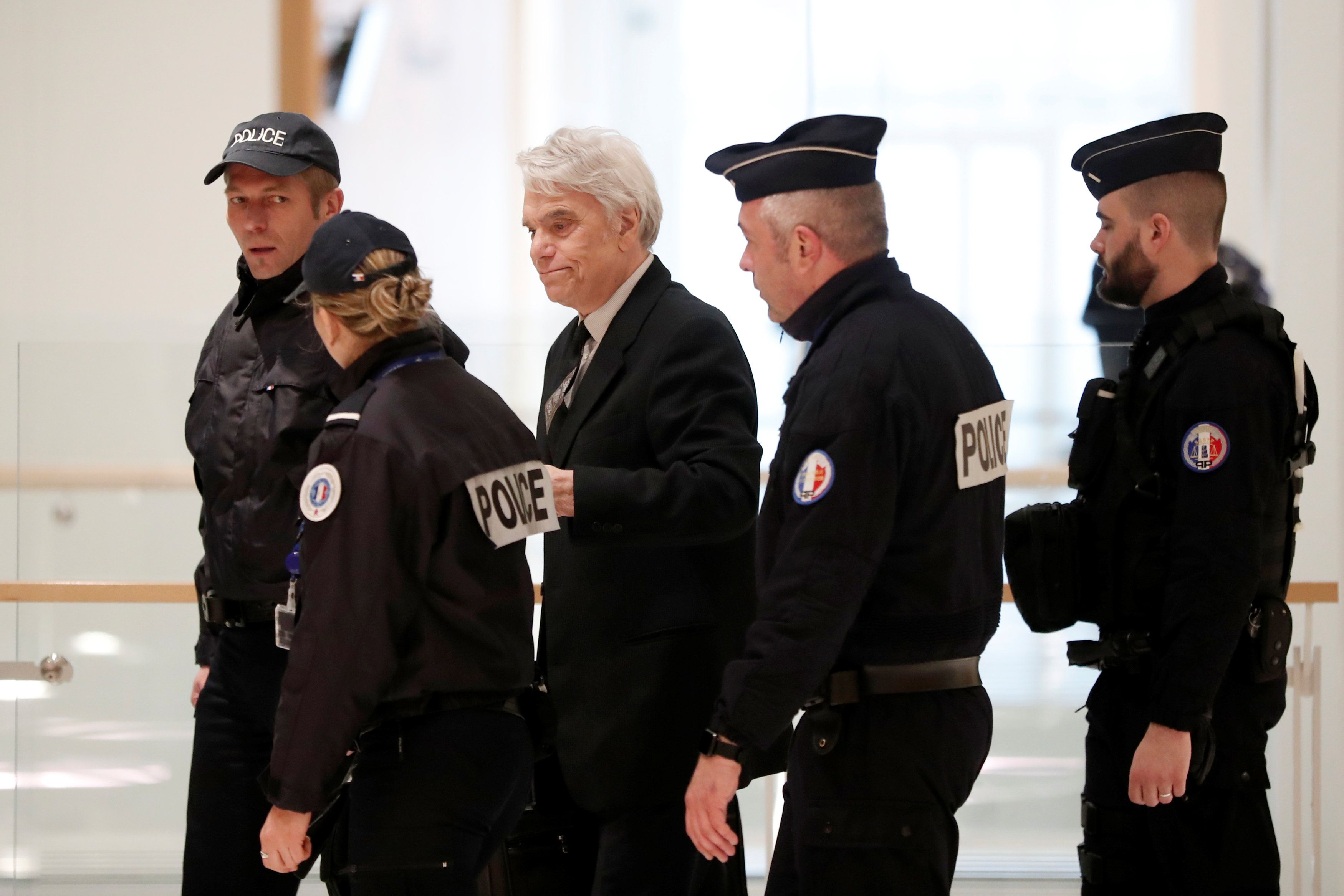 El polémico empresario, dirigente deportivo y político francés Bernard Tapie, escoltado por la policía, llega a una audiencia judicial a raíz de una millonaria asignación de fondos a su favor que en 2008 dispuso Lagarde