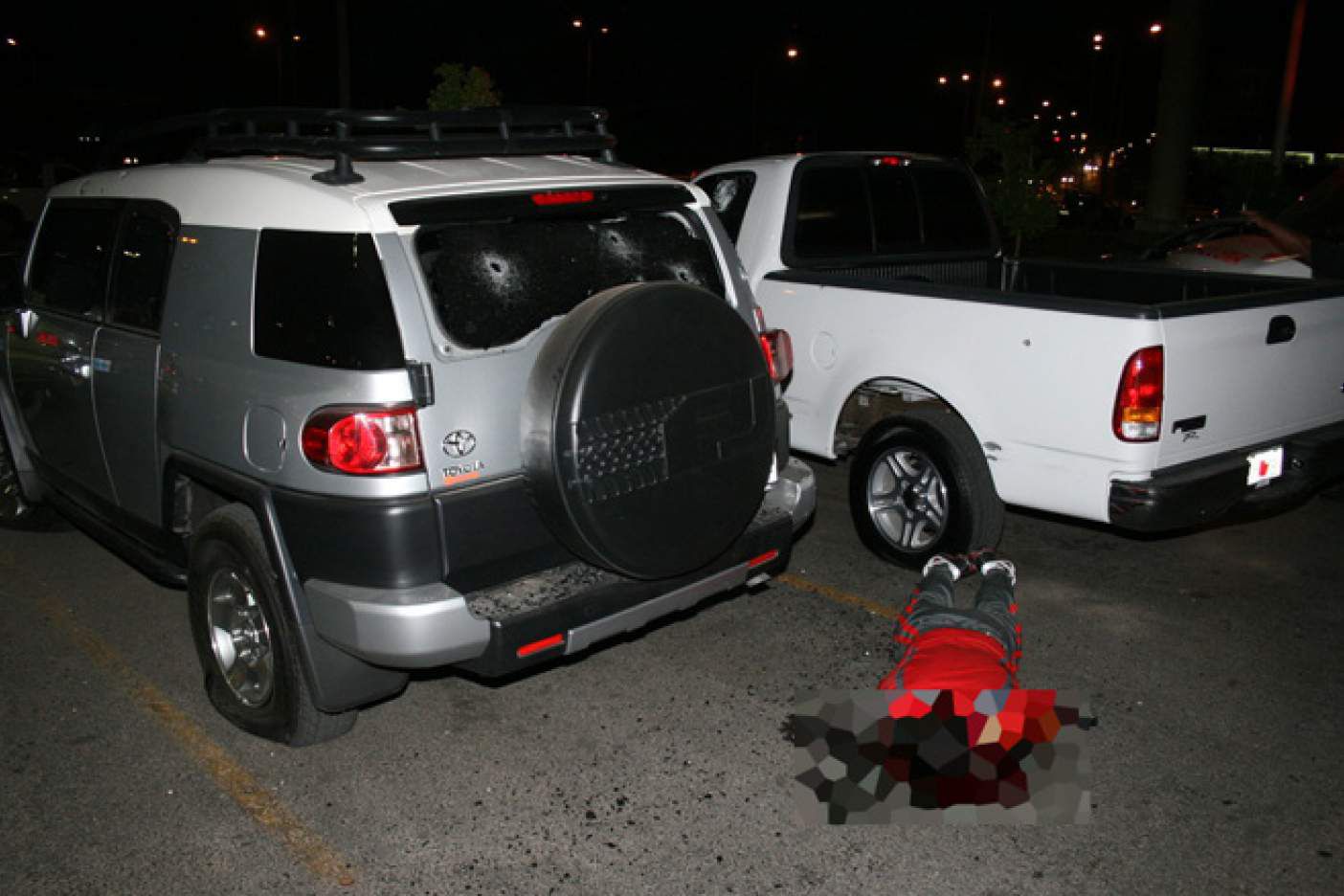 El cuerpo sin vida de Édgar Guzmán López, hijo de "El Chapo" Guzmán tendido en el piso del estacionamiento de un supermercado en el centro de Culiacán, Sinaloa (Gentileza: Diario Noroeste)