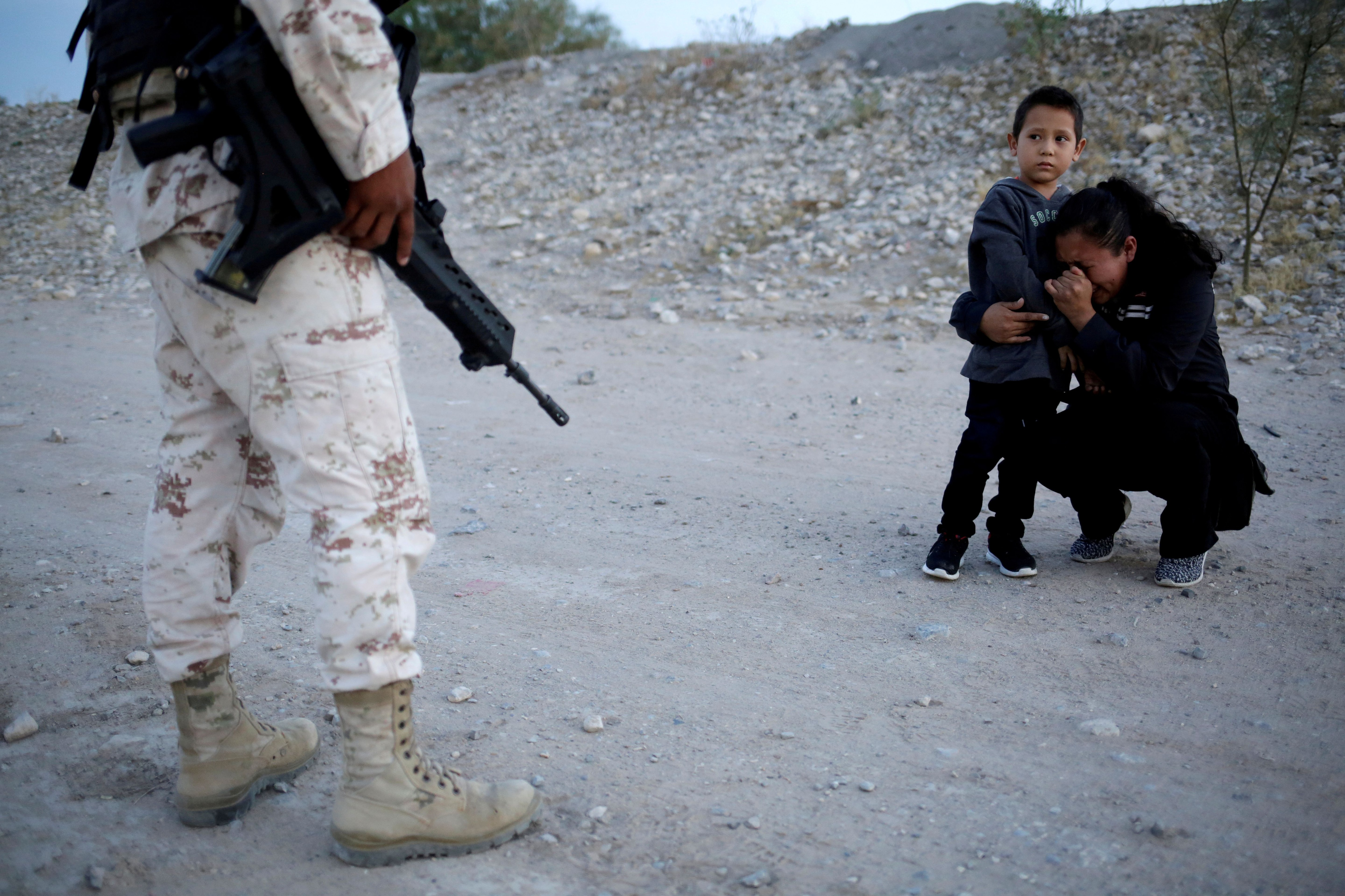 La migrante guatemalteca Ledy Pérez abraza a su hijo Anthony mientras reza para pedirle a un miembro de la Guardia Nacional Mexicana que les permita cruzar a los Estados Unidos, como se ve desde Ciudad Juárez, México, el 22 de julio de 2019 REUTERS/Jose Luis Gonzalez