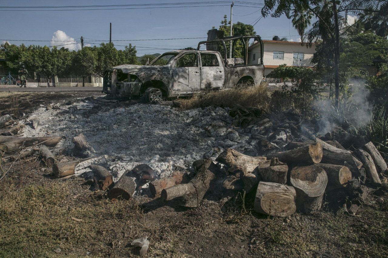 LOS REYES (MÉXICO), 21/10/2019.- Vista general este lunes de un autobús incendiado para bloquear el acceso a los poblados de Tocombo y Los Reyes, en occidental estado de Michoacán (México). Presuntos sicarios al servicio del Cártel Jalisco Nueva Generación (CJNG) realizaron al menos dos bloqueos en Michoacán, cuando se cumple una semana del ataque a un convoy de la Policía Estatal que dejó 13 oficiales muertos y 9 heridos. De acuerdo con fuentes del servicio telefónico de emergencias 911, consultadas por Efe, automovilistas reportaron la mañana de este lunes la presencia de más de cien hombres armados con rifles de asalto en dos puntos de la carretera estatal que une los municipios de Tocumbo y Los Reyes.
(FOTO: JUAN JOSÉ ESTARADA SERAFÍN /CUARTOSCURO)