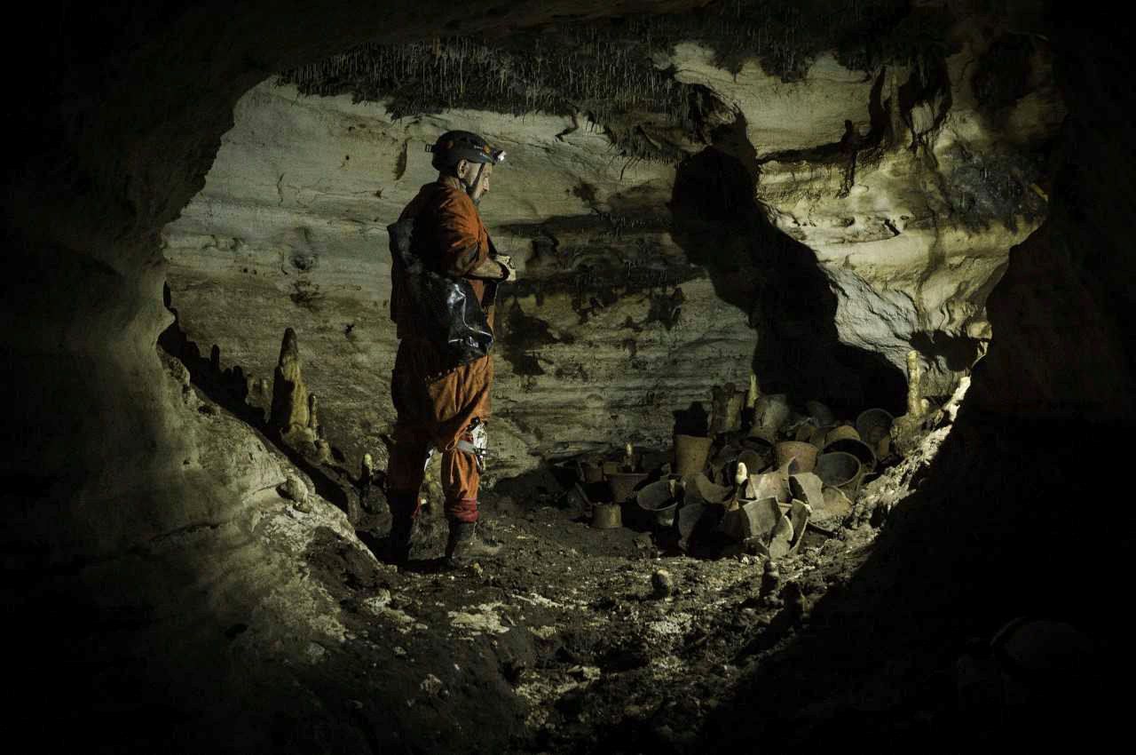 El arqueólogo Guillermo de Anda observa un artefacto prehispánico en la cueva Balamku, ubicada en el sitio arqueológico de Chichén Itzá en la península de Yucatán, México, 4 de marzo de 2019. Fotografía tomada el 4 de marzo de 2019. INAH - Instituto Nacional de Antropología e Historia / Karla Ortega