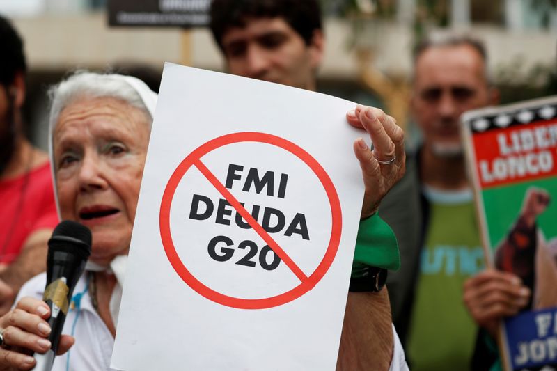 Una mujer, integrante de la organización de derechos humanos Madres de la Plaza de Mayo de Argentina, sostiene un cartel en alusión de la carga de deuda del país, que involucran negociaciones con el FMI y naciones del G20, durante una protesta en Buenos Aires.. FOTO DE ARCHIVO. REUTERS/Carlos Garcia Rawlins