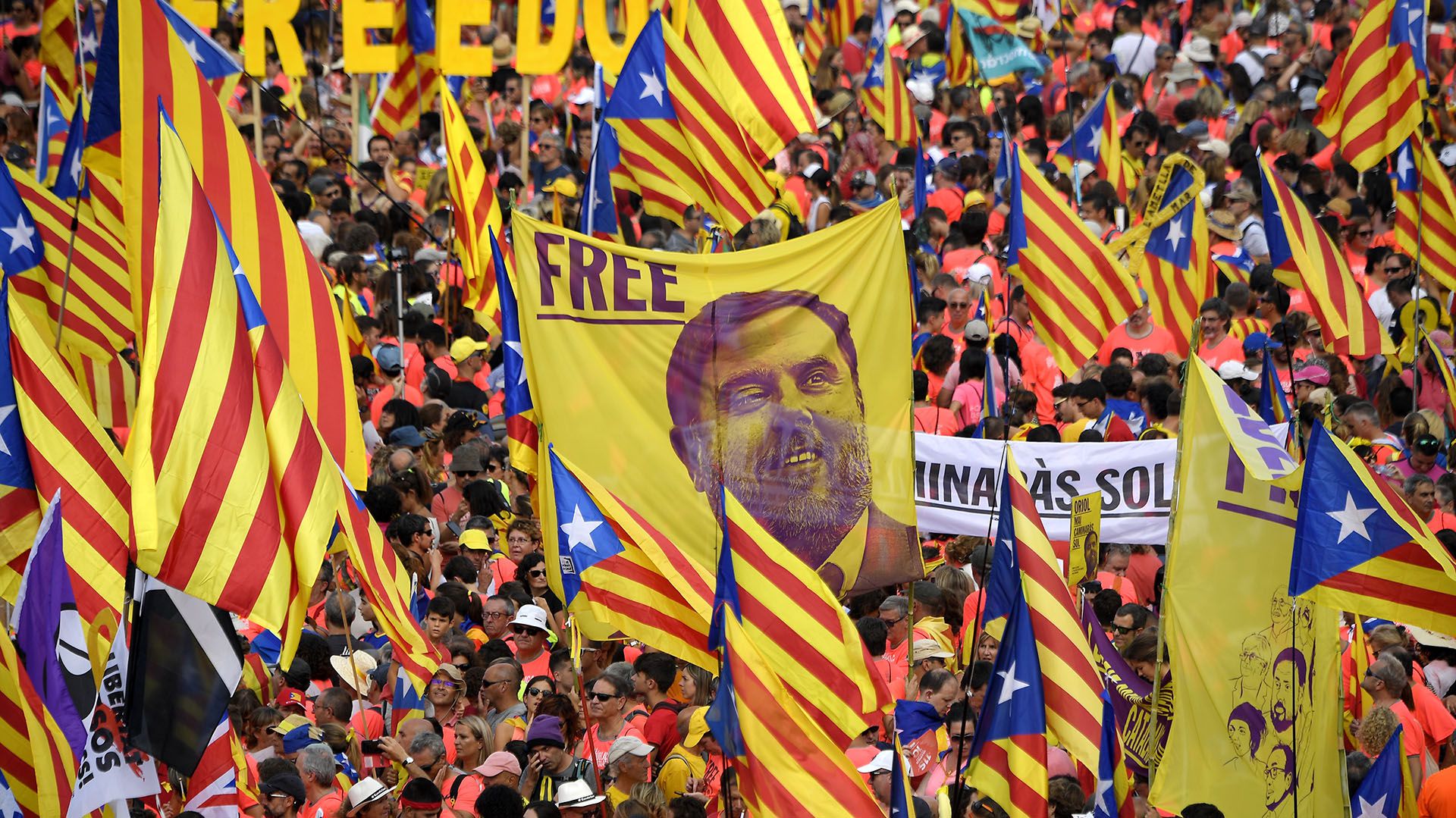 Manifestantes sostienen un estandarte que exige libertad para el dirigente encarcelado catalán Oriol Junqueras mientras se reúnen para participar en una manifestación independentista en Barcelon (LLUIS GENE / AFP)