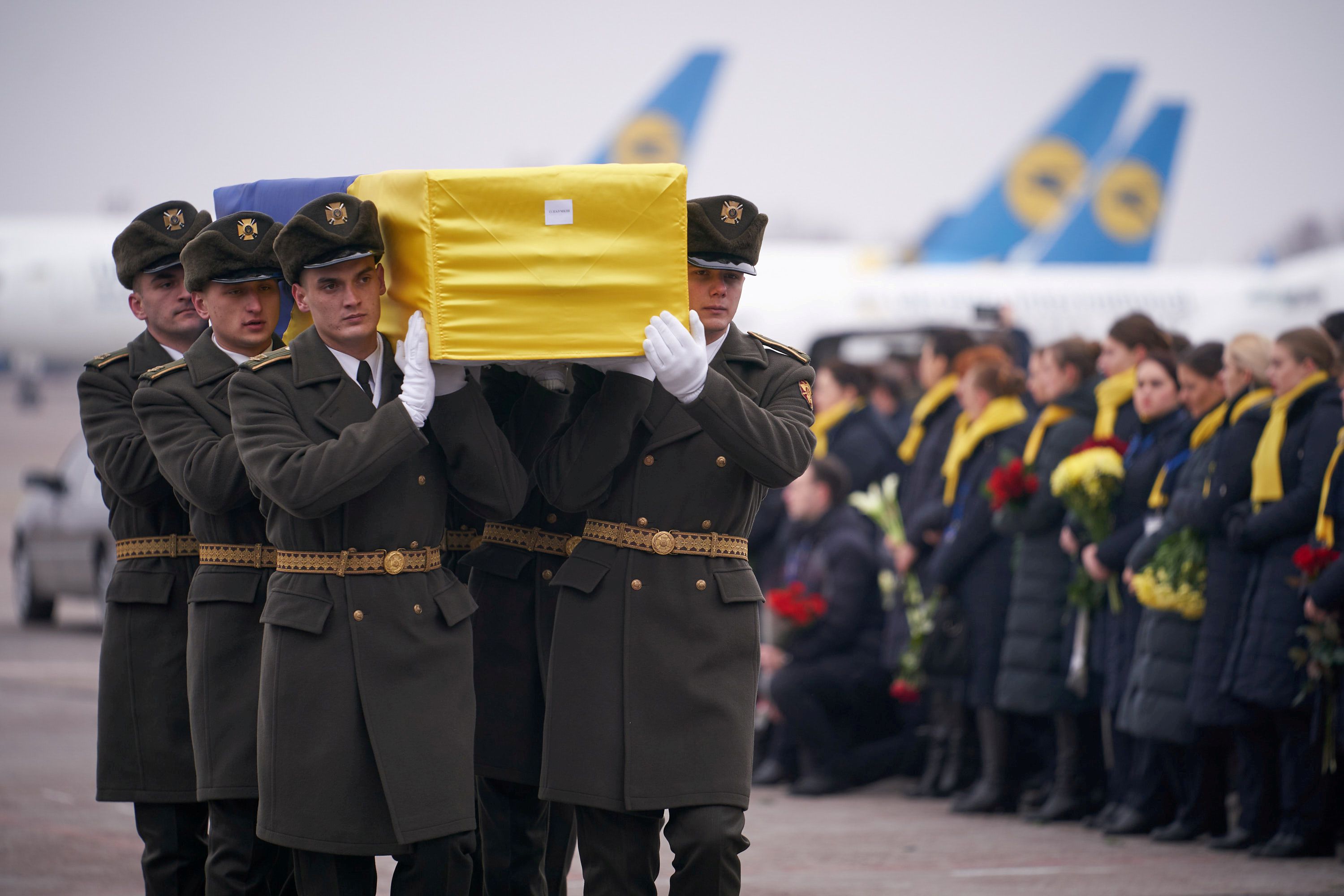 Solados en Kiev cargando los restos de la víctima de la avión en Irán. via REUTERS 