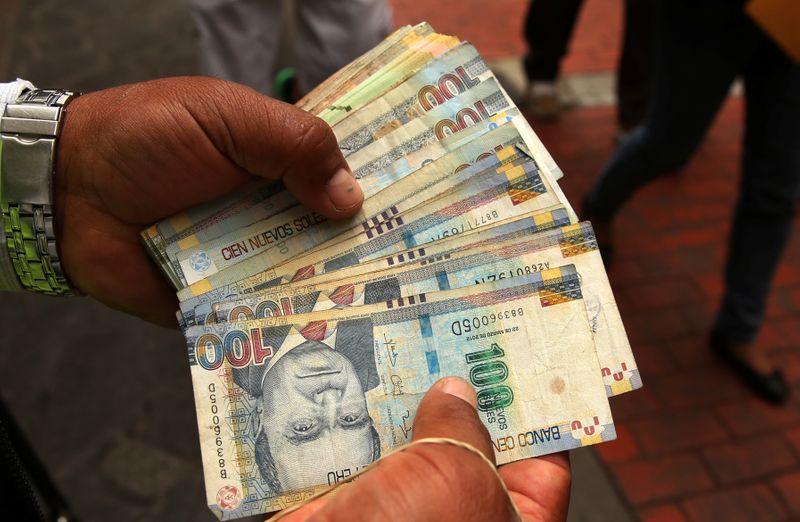 Foto de archivo. Un cambiador de dinero tiene billetes de sol peruano en una calle del centro de Lima, Perú, 15 de diciembre, 2017. REUTERS/Mariana Bazo