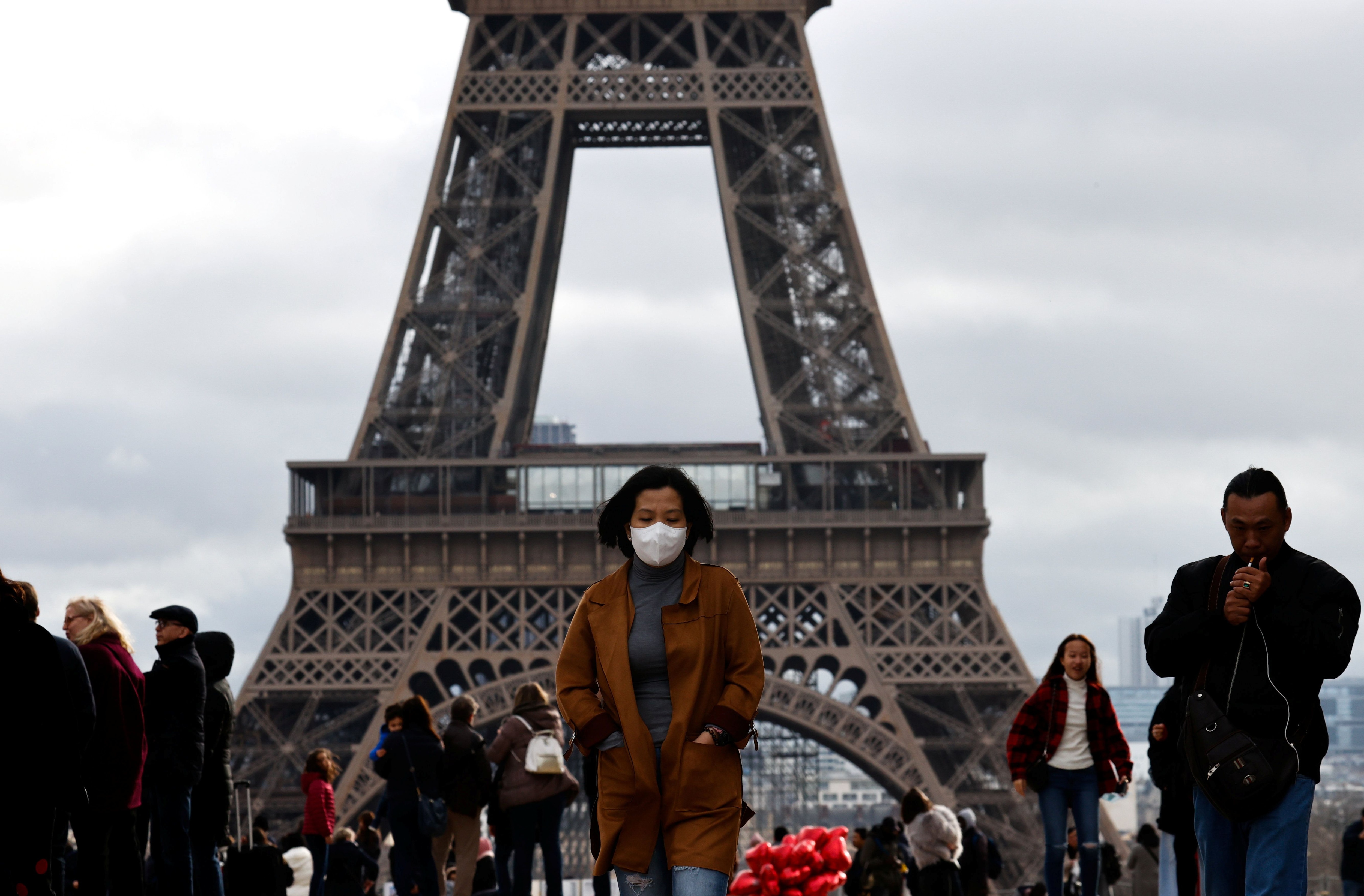 Una mujer se protege el rostro por temor a contagiarse de coronavirus frente a la Torre Eiffel de París el 1 de febrero de 2020 (REUTERS/Gonzalo Fuentes)