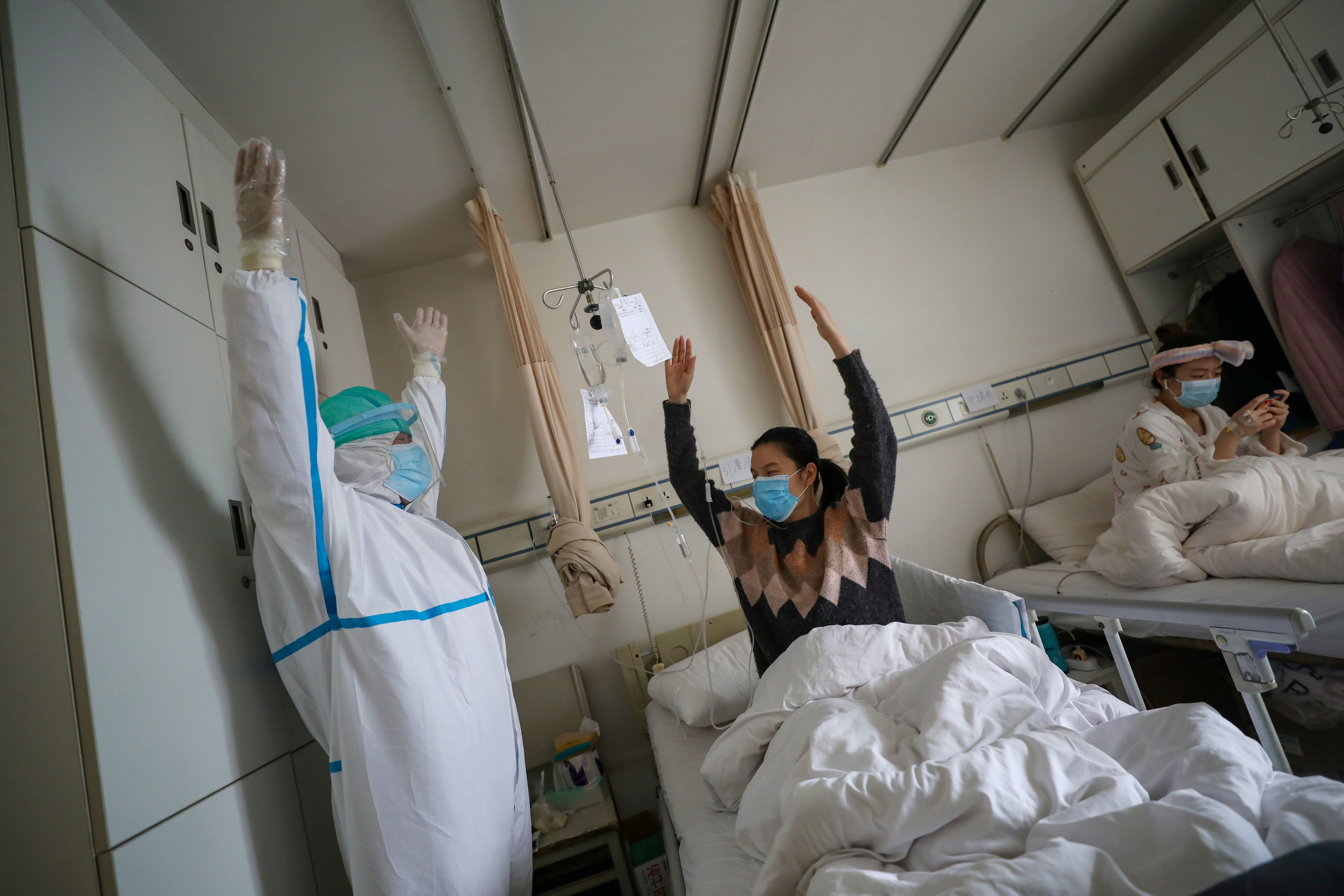 Un médico protegido realiza ejercicios con un paciente en el centro de rehabilitación del hospital de la Cruz Roja en Wuhan (China Daily via REUTERS)