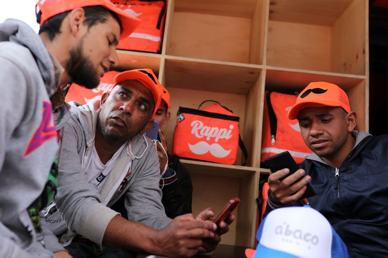 Repartidores de Rappi usan sus celulares para ver la aplicación de entregas a domicilio en Bogotá. ARCHIVO. REUTERS/Luisa Gonzalez