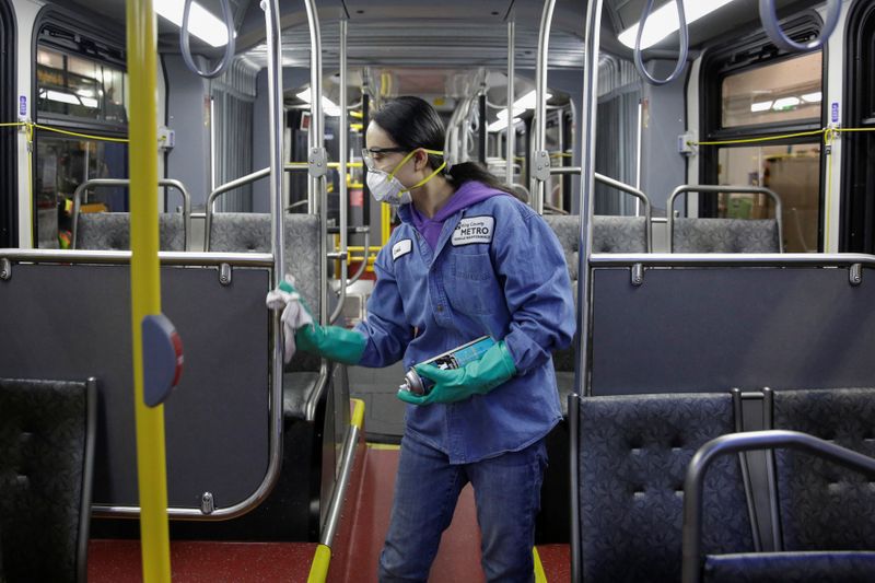 El trabajador del servicio de mantenimiento de vehículos Thiphavanh 'Loui' Thepvongsa limpia un autobús fuera de servicio con un desinfectante durante una limpieza de rutina en el King County Metro Atlantic y la Base Central en Seattle, Washington (REUTERS / Jason Redmond)