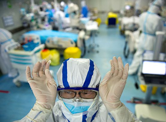 Esta foto tomada el 22 de febrero de 2020 muestra a una enfermera ajustando sus gafas en una unidad de cuidados intensivos que trata a pacientes con coronavirus COVID-19 en un hospital de Wuhan, en la provincia central de Hubei en China(Foto de STR / AFP)