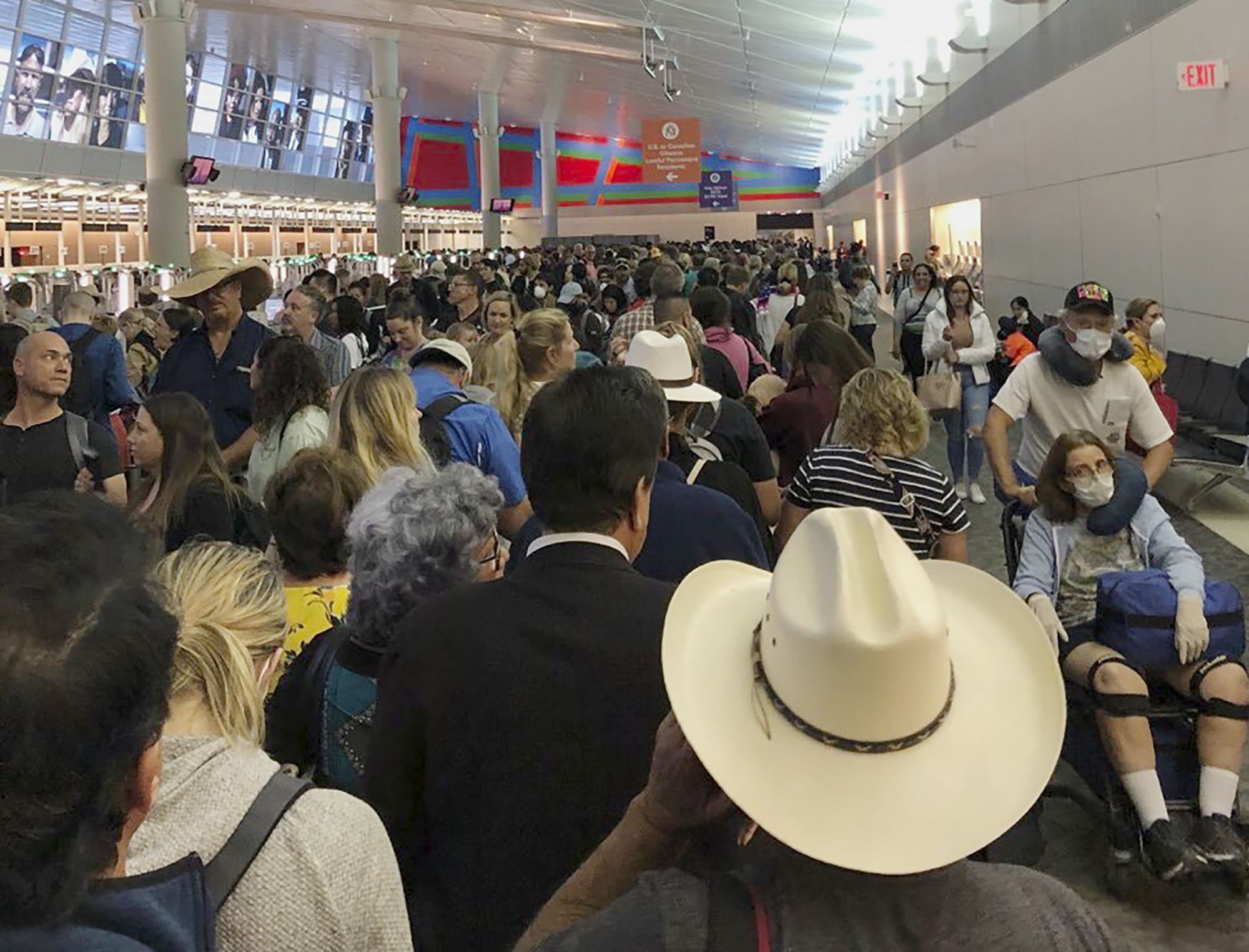 Pasajeros esperando a pasar la aduana en el Aeropuerto Internacional de Dallas Fort Worth en Texas (Austin Boschen via AP)