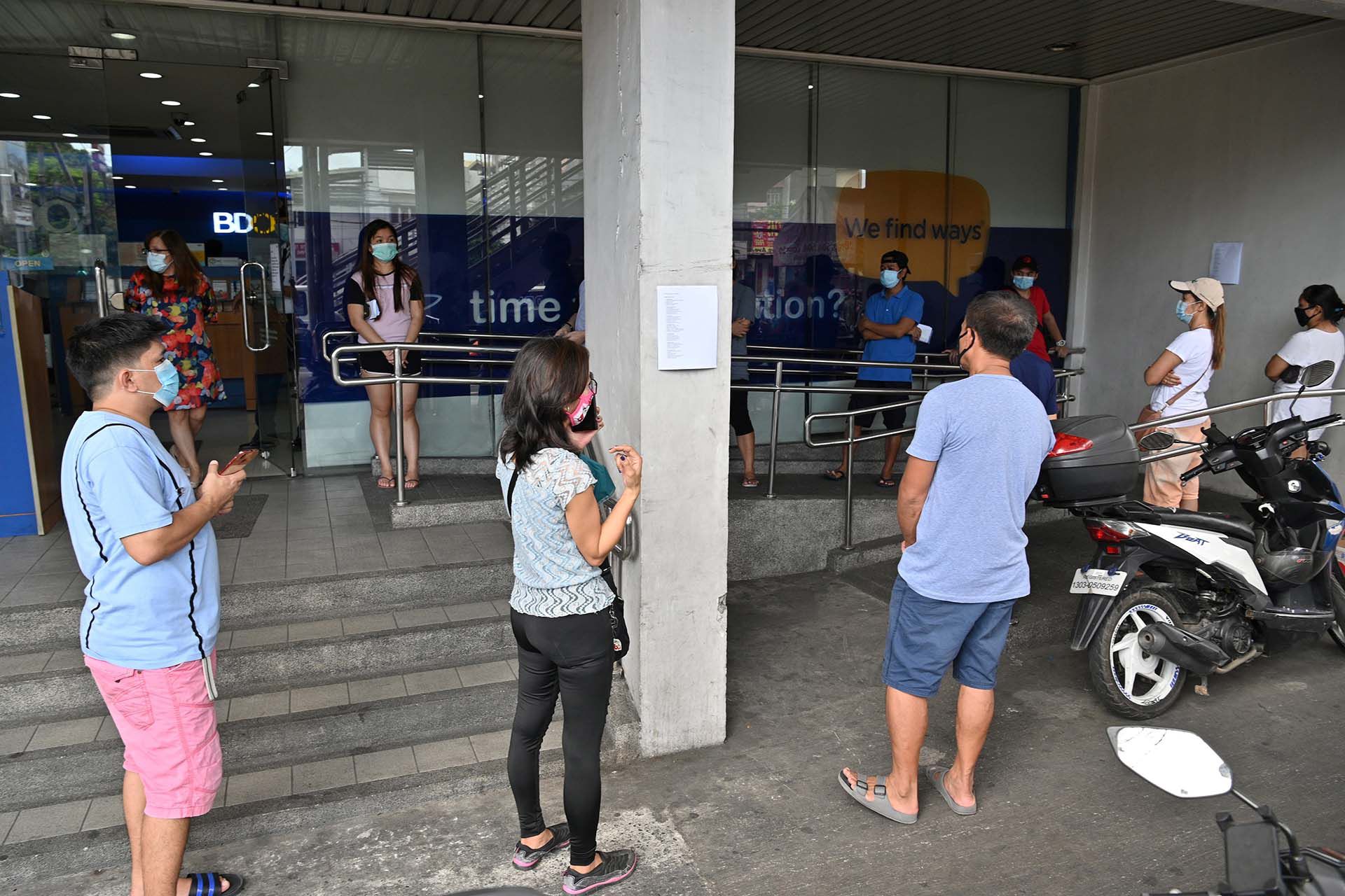 Clientes hacen fila para ingresar en una sucursal bancaria en Manila, Filipinas. 