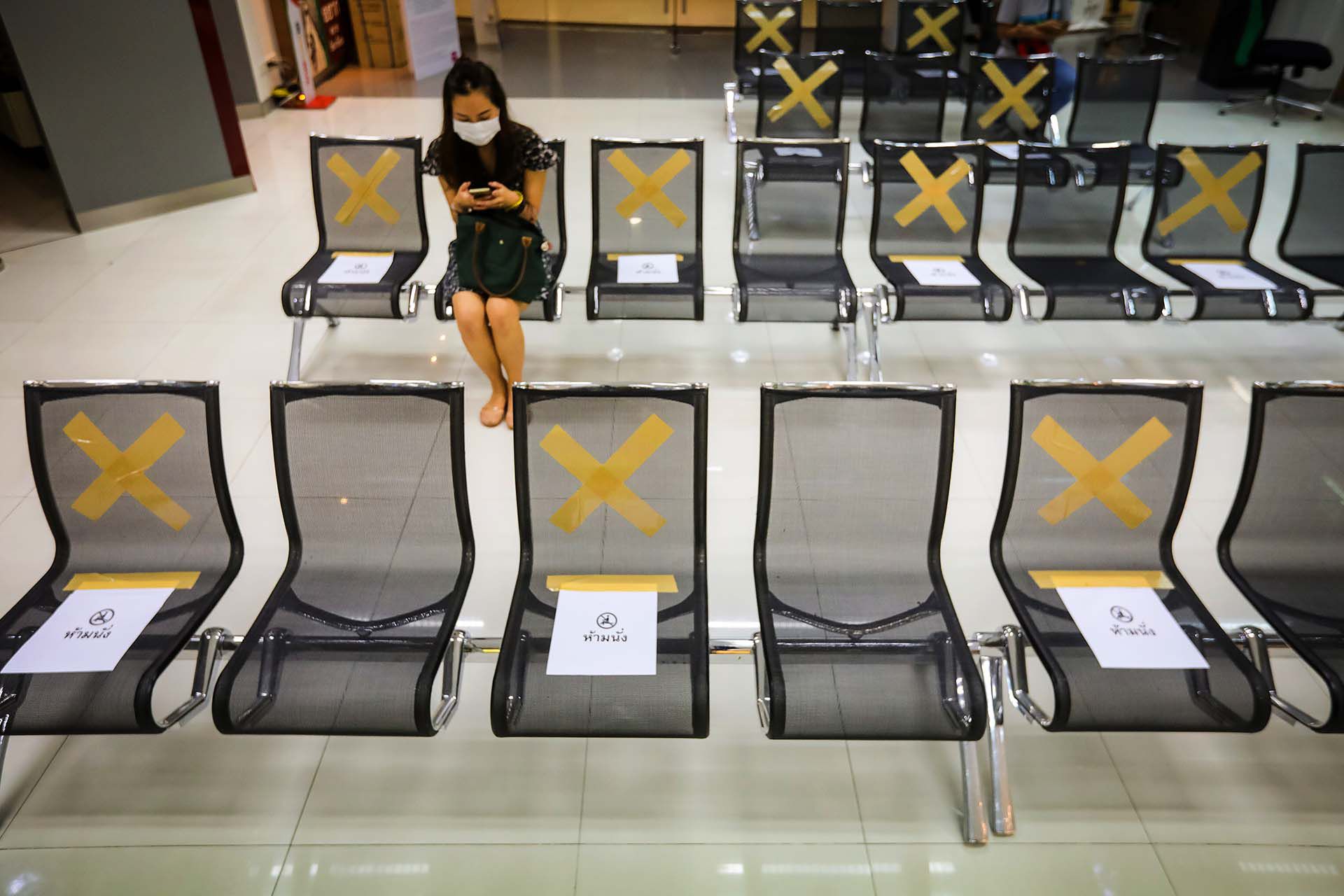 Una sucursal bancaria de Bangkok muestra en qué sillas sentarse y en cuáles no. 