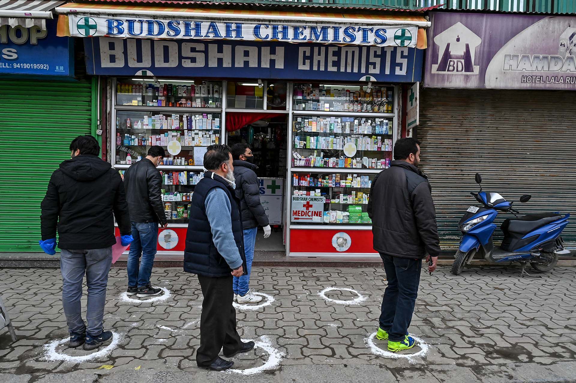 Gente hace fila frente a una farmacia en Srinagar, India. 