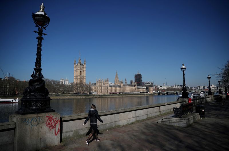 Una mujer camina frente a las Cámaras del Parlamento británico, en la ribera del río Támesis, mientras continúa la propagación del coronavirus en Londres, Reino Unido, el 25 de marzo de 2020. REUTERS/Hannah Mckay