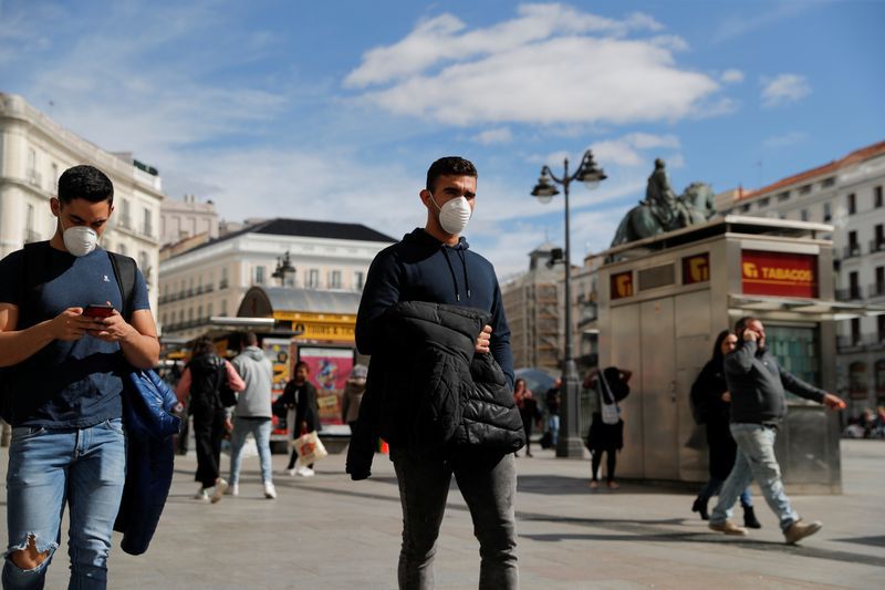 FOTO DE ARCHIVO. Hombres con mascarilla caminan por la Puerta del Sol, en Madrid, España. 4 de marzo de 2020. REUTERS/Susana Vera.