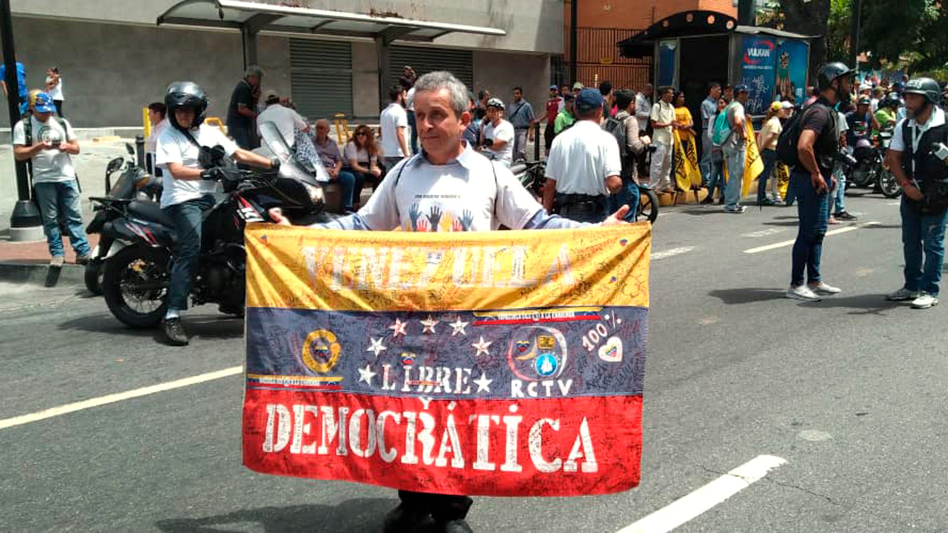 "Venezuela libre y democrática", la leyenda escrita en una bandera mostrada por un manifestante