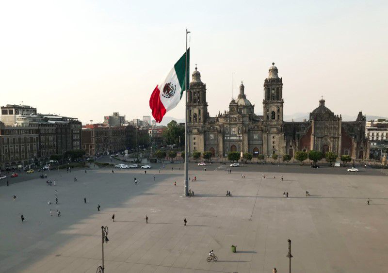 Imagen de archivo. Personas caminan cerca de la bandera nacional en una Plaza del Zócalo parcialmente vacía a medida que el coronavirus se extiende por Ciudad de México, México. 25 de marzo de 2020. REUTERS/Henry Romero
