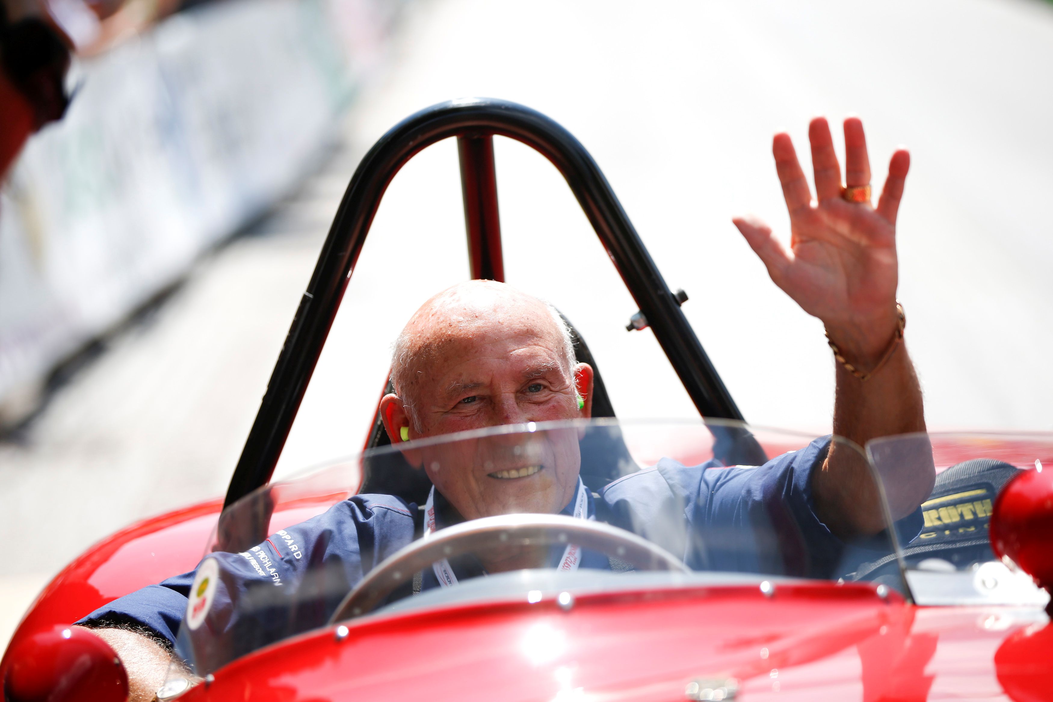 FILE PHOTO: Former English Formula One driver Stirling Moss waves to spectators as he sits in his 1955 Ferrari 750 Monza during the Ennstal Classic rally near the Austrian village of Groebming July 20, 2013. REUTERS/Leonhard Foeger (AUSTRIA - Tags: SPORT MOTORSPORT SOCIETY)/File Photo