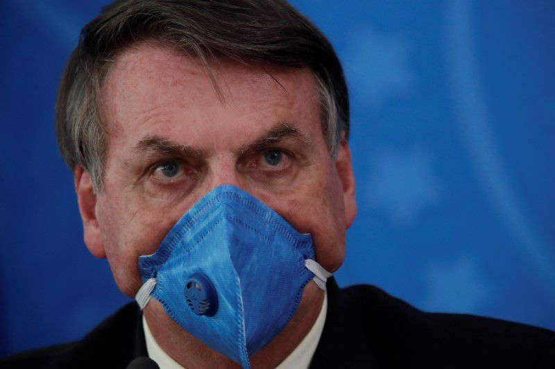 El presidente de Brasil, Jair Bolsonaro, usando un barbijo durante una conferencia de prensa en medio del brote de la pandemia del COVID-19, cuyos efectos definió como "de una gripecita". REUTERS/Ueslei Marcelino
