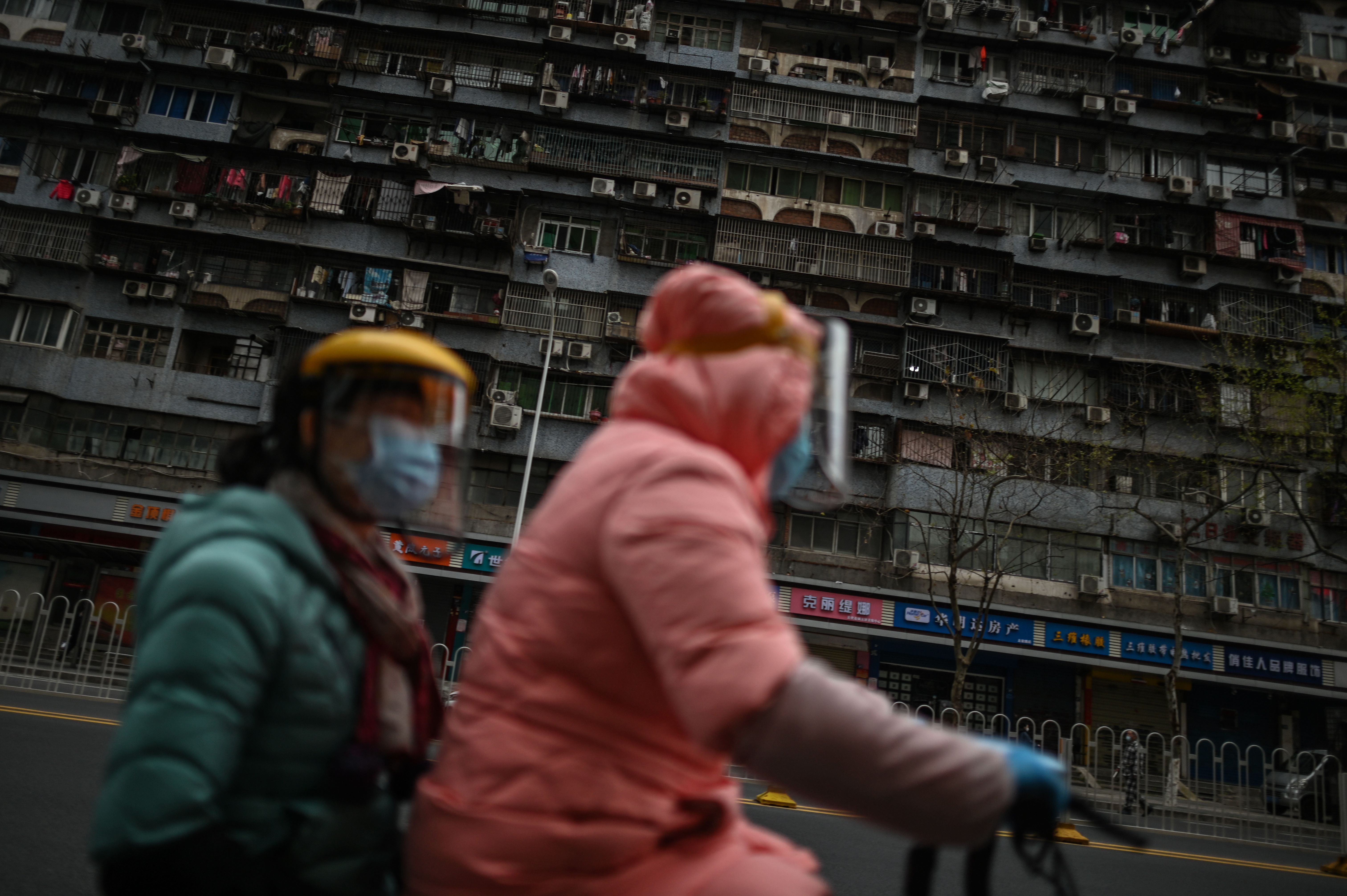 Dos mujeres en una moto en Wuhan (Hector RETAMAL / AFP)