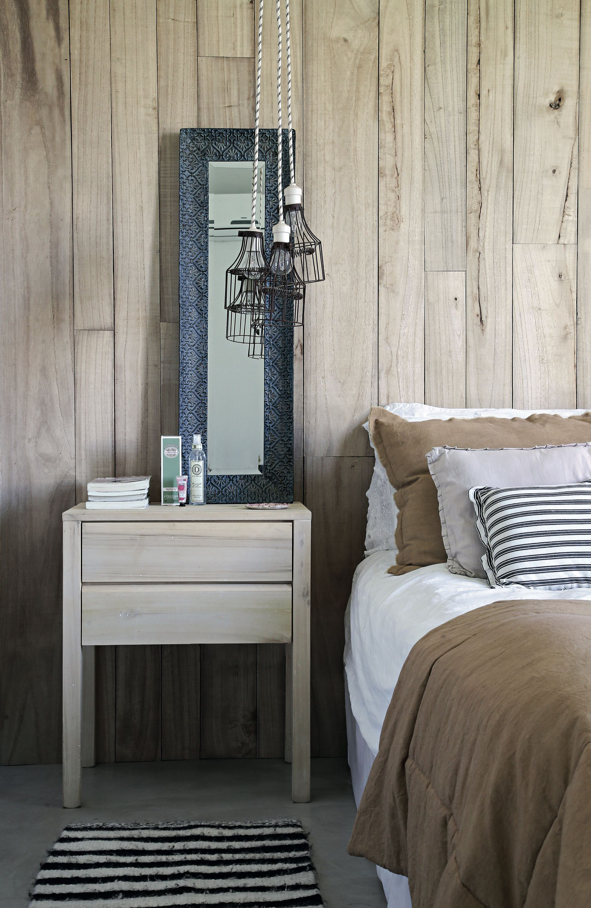 Un entablonado de madera de kiri le da respaldo a la cama en el cuarto principal.