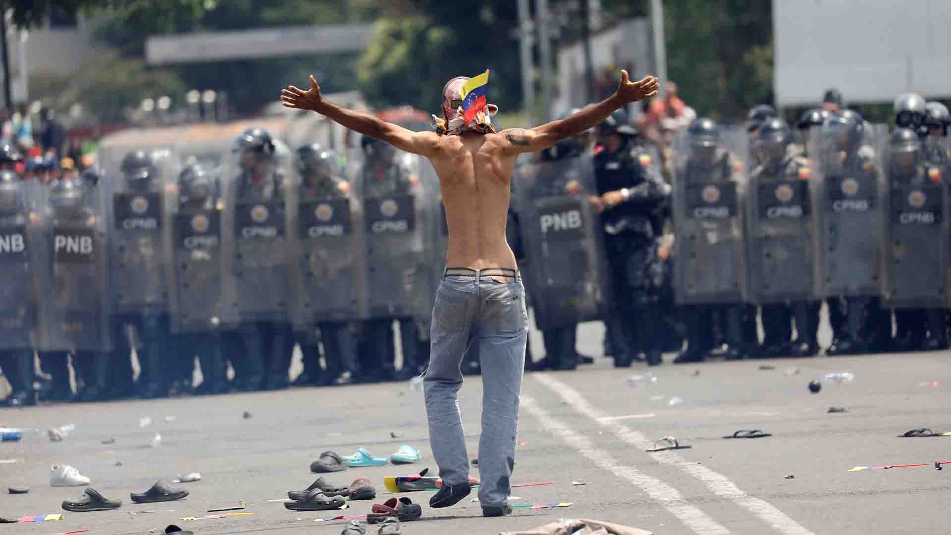 Un venezolano levanta sus brazos frente policías (REUTERS/Edgard Garrido)