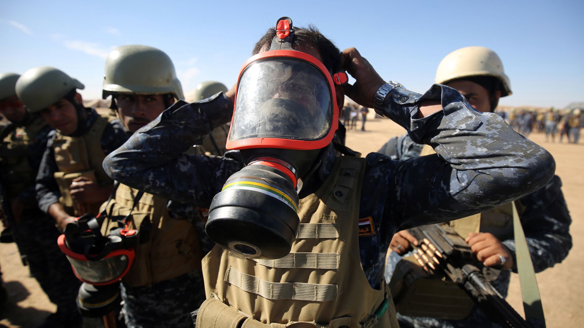 Un policía iraquí usa una máscara de gas, al sur de Mosul (AFP)