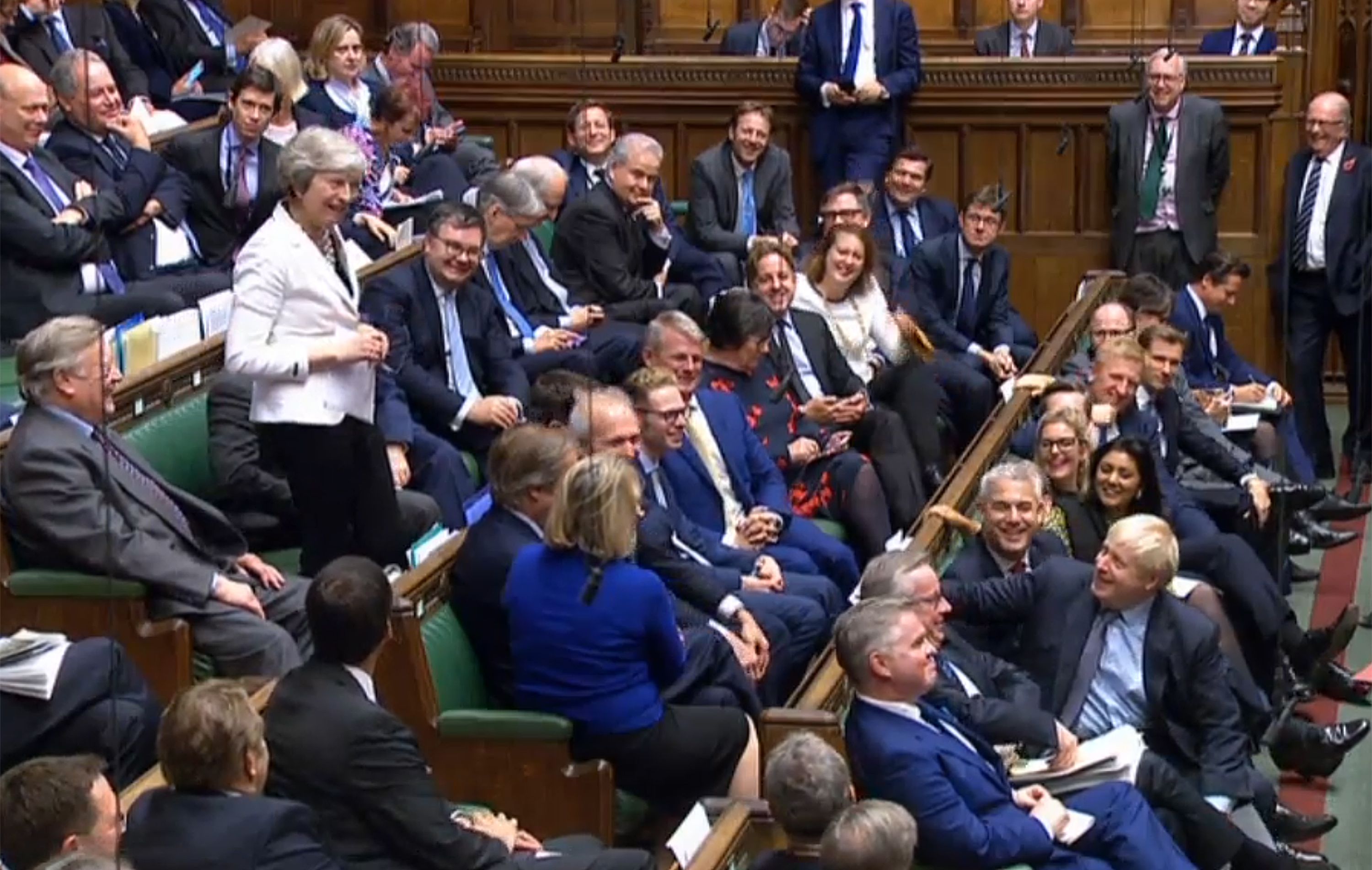 La ex premier Theresa May bromea con Boris Johnson antes de la votación (AFP)
