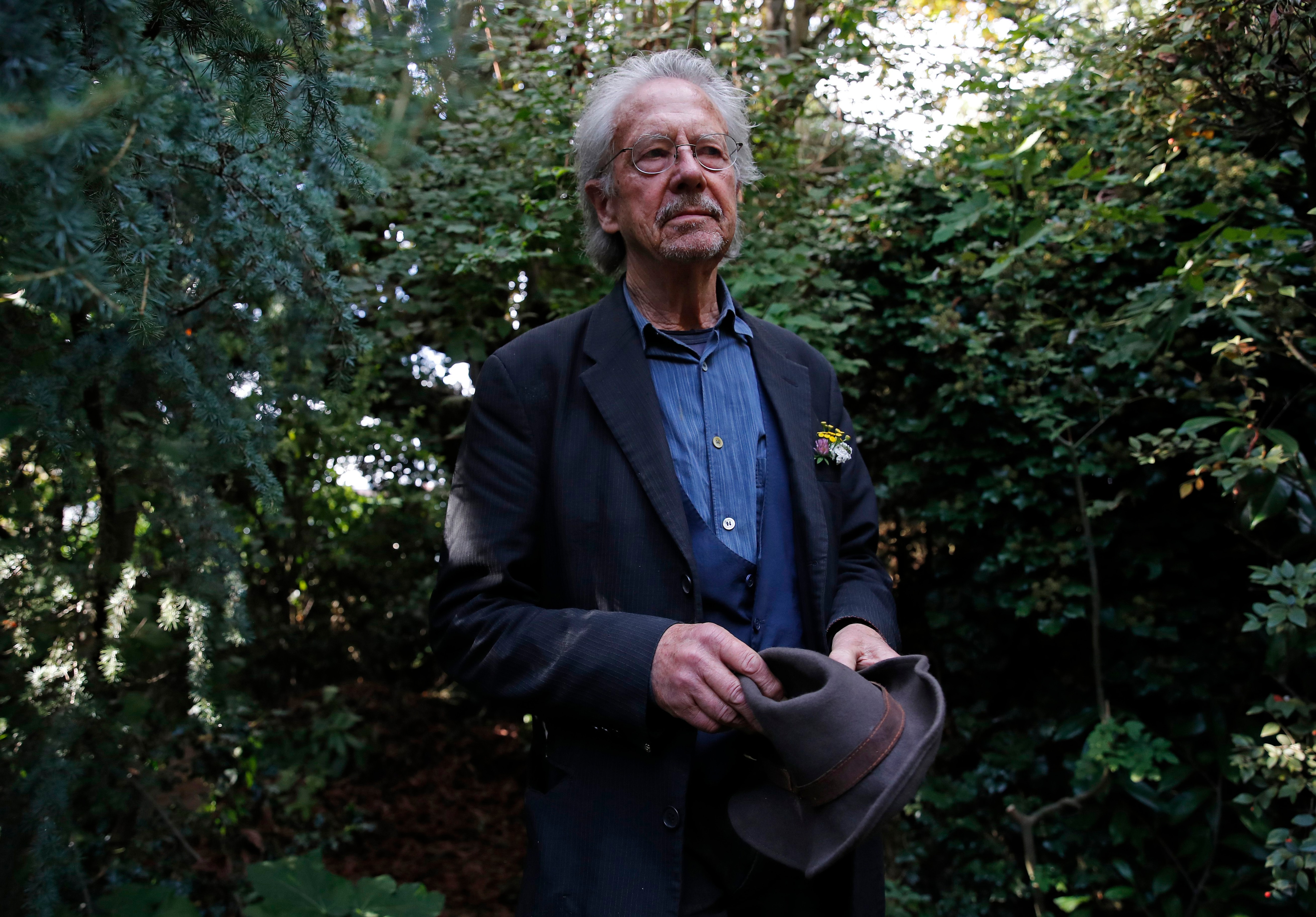El autor austríaco Peter Handke posa en el jardín de su casa en Chaville, cerca de París, el jueves 10 de octubre de 2019. Handke fue galardonado horas antes con el premio Nobel de Literatura 2019. (AP Foto/Francois Mori)