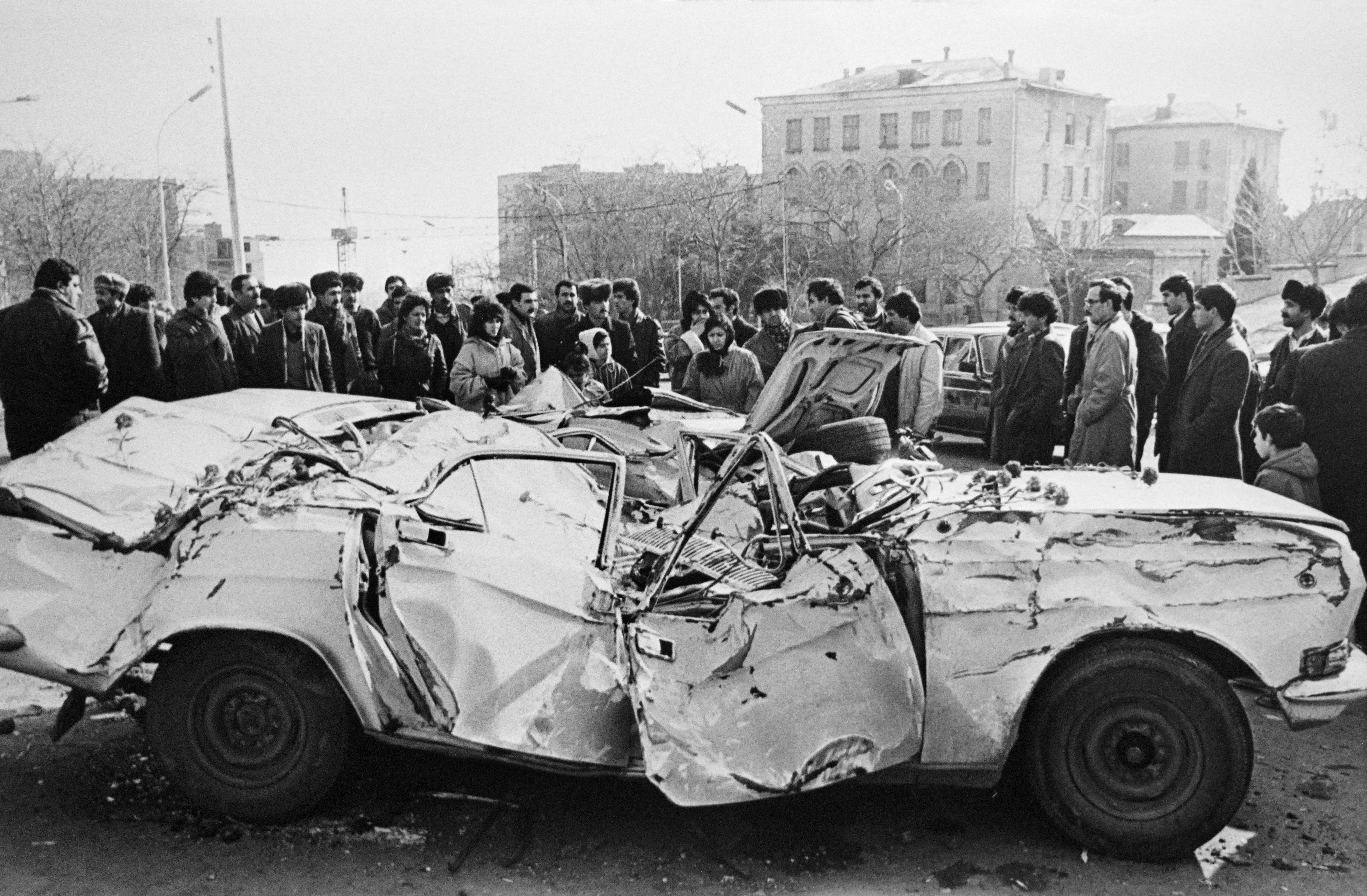 Azerbaiyanos observan un auto destruido durante la invasión soviética de Bakú (AFP)